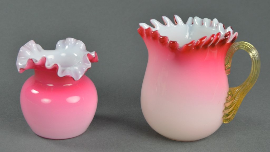 Two Pieces Peachblow Art Glass: One creamer with square serrated rim and applied reeded amber handle on pitcher, 3 1/2" H.; and one toothpick holder having indented ruffled rim, 2 3/4" H. Both with cased white interiors.