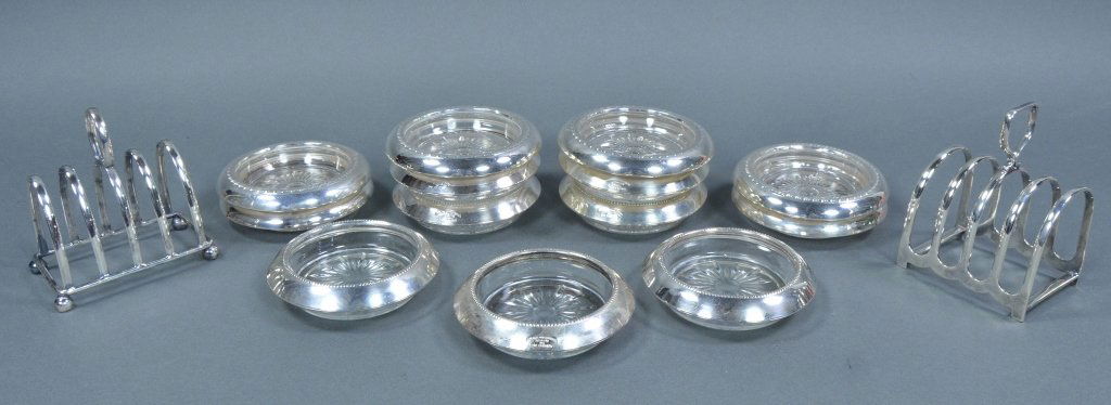 Group of Sterling Rimmed Glass Coasters: Seven of one pattern and 6 of another. 4" Dia. Along with two silverplate toast racks, 4 1/2" H.