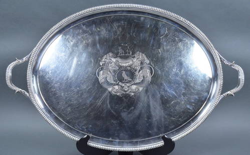 British Sterling Oval Waiter: Having elaborate engraved coat of arms with motto, "Deus Pascit Corvos" (God Feeds the Ravens). Footed and with handles. Having hallmark with lion passant, leopard's head, date letter "I", and soverei
