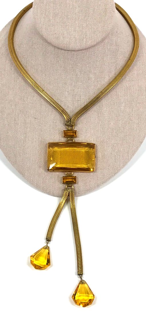 Vintage Art Deco Open Back Crystals Dangles Necklace: Vintage art deco yellowish faceted crystals goldtoned metal choker necklace with dangles. Snake chain strap measures around 16 inches long end to end. For measures please refer to the picture taken wi