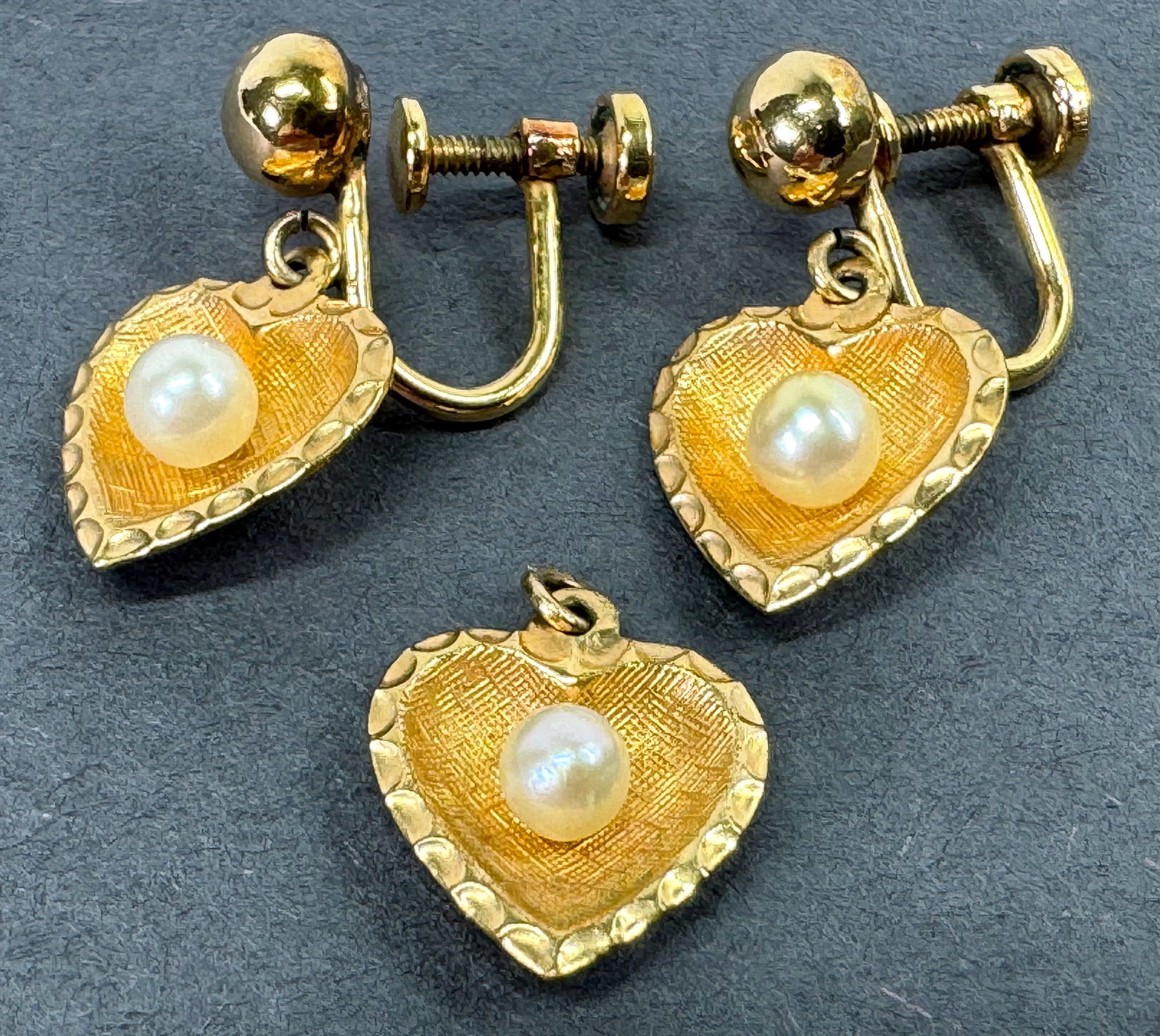 Vintage 12K gold filled faux pearl heart screw earrings + miniature pendant. Marked: Vintage 12K gold filled faux pearl heart screw earrings + miniature pendant. Marked M inside a diamond 1/20 12K For measures please refer to the pictures taken with a measuring tape. Weight: 3 Grams. 