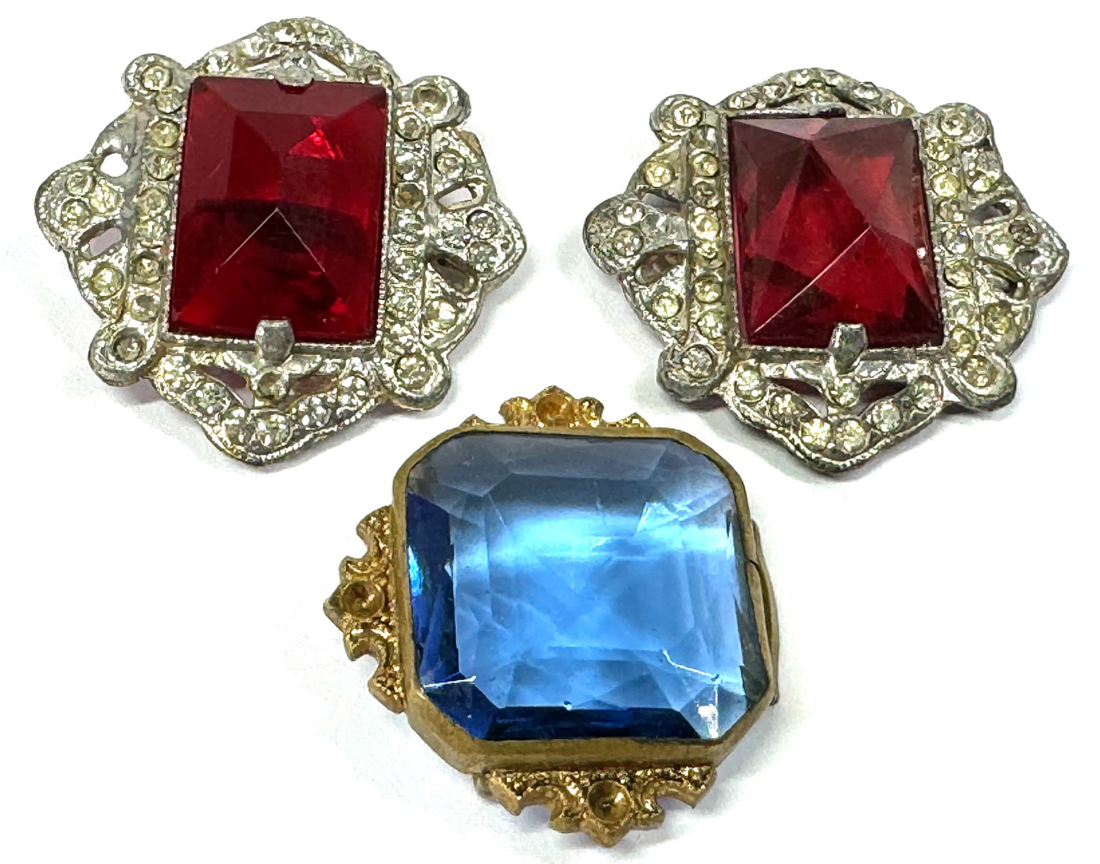 Antique art deco open back crystal buttons and buckle piece: Antique art deco open back red crystal & clear rhinestones silvertone metal buttons and a blue crystal goldtone metal buckle piece for repurpose. For measures please refer to the pictures taken with a