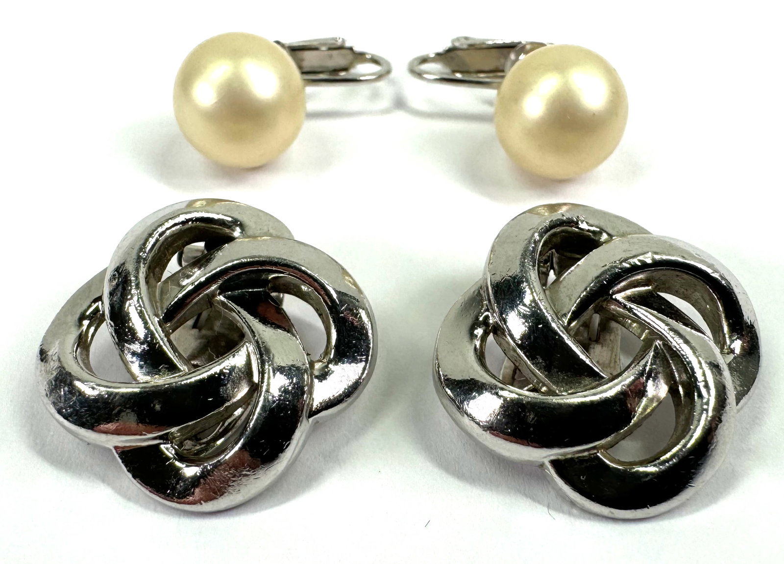 Vintage Crown Trifari silvertone infinity knots & faux pearl clip earrings.: Vintage Crown Trifari silvertone infinity knots & faux pearl clip earrings. Both are marked. For measures please refer to the pictures that were taken with a measuring tape. Weight: 16 Grams all. This