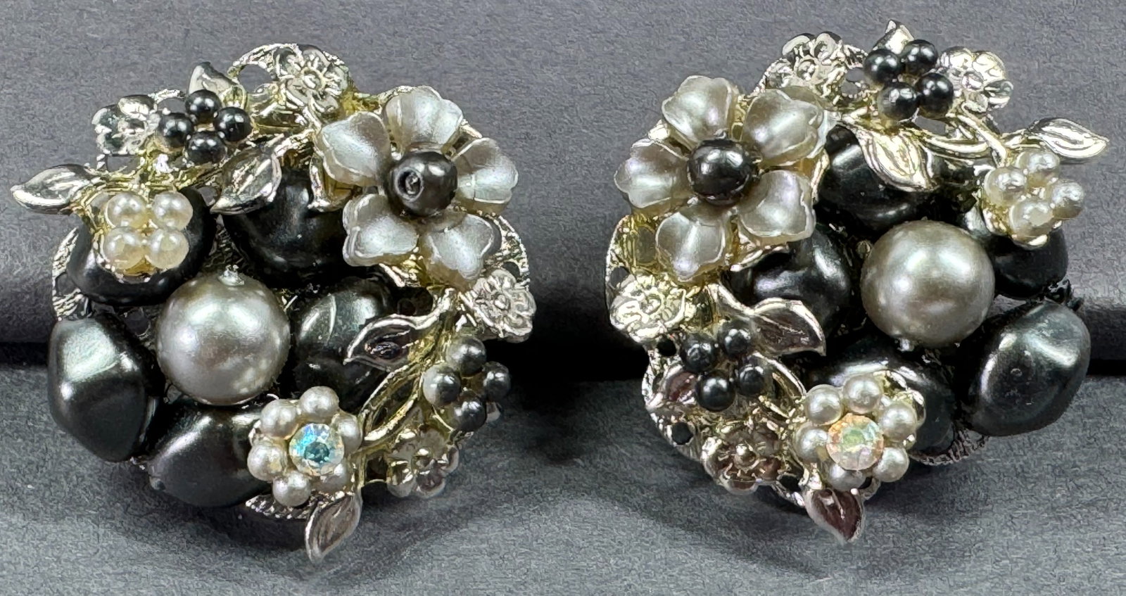 Vintage Haskell style pearly plastic & AB crystals flower leaves filigree silvertone clip earrings.: Vintage Haskell style pearly plastic & AB rhinestones flowers and leaves filigree silvertone metal clip earrings. Unmarked. For measures please refer to the pictures taken with a measuring tape. Weigh