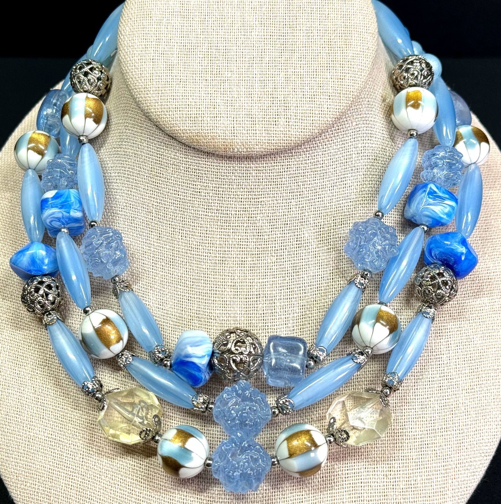 Vintage Coro filigree silvertone metal bluish lucite & plastic beads 3 strands necklace.: Vintage Coro filigree silvertone metal bluish lucite & plastic beads 3 strands necklace. Silvertone metal flower clasp. Marked Coro. For measures please refer to the pictures taken with a measuring ta