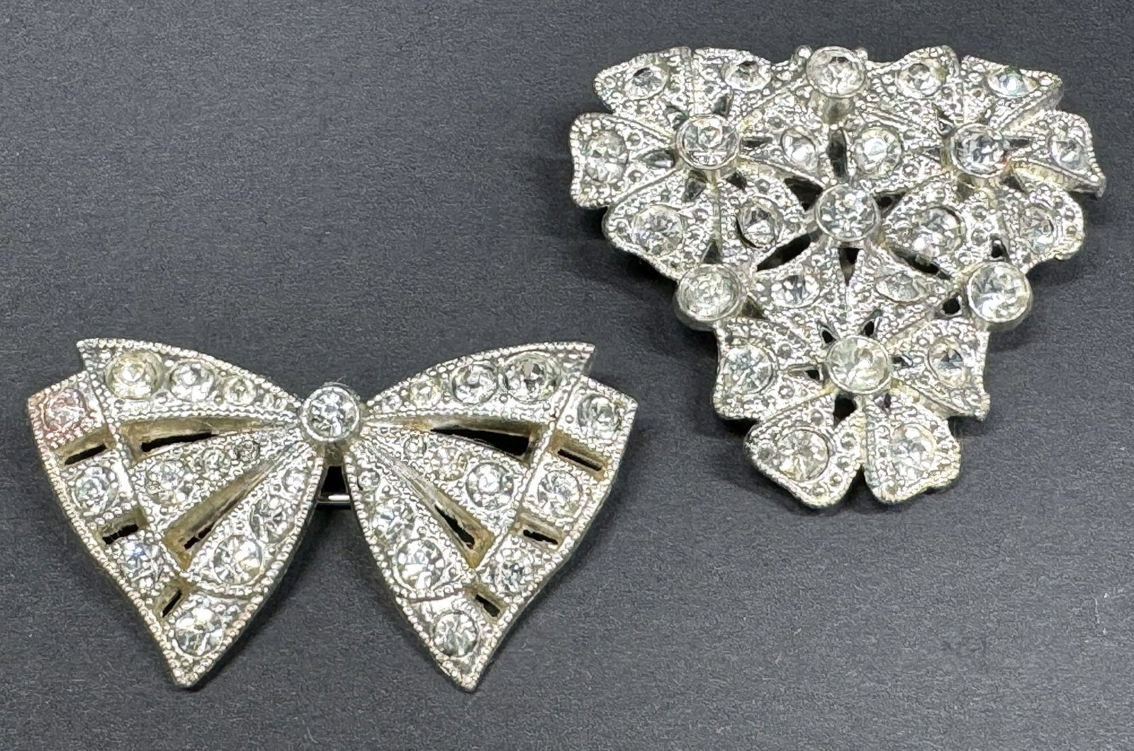 Antique clear rhinestones pot metal flowers dress clip & signed Goody bow pin brooch.: Antique clear rhinestones pot metal flowers dress clip & signed Goody bow pin brooch. Marked on the pin bar. For measures please refer to the pictures taken with a measuring tape. Weight: 21 Grams. Th