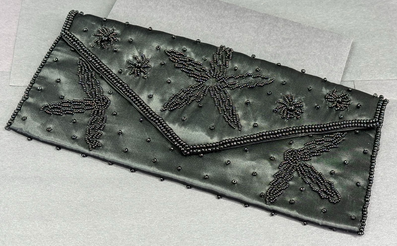 Vintage Japanese Bags by Debbie black glass beaded silky clutch purse.: Vintage Japanese Bags by Debbie black glass beaded silky clutch purse. Fabric label. Snap closure. The interior is lined with one pocket (dirt). For measures please refer to the pictures taken with a