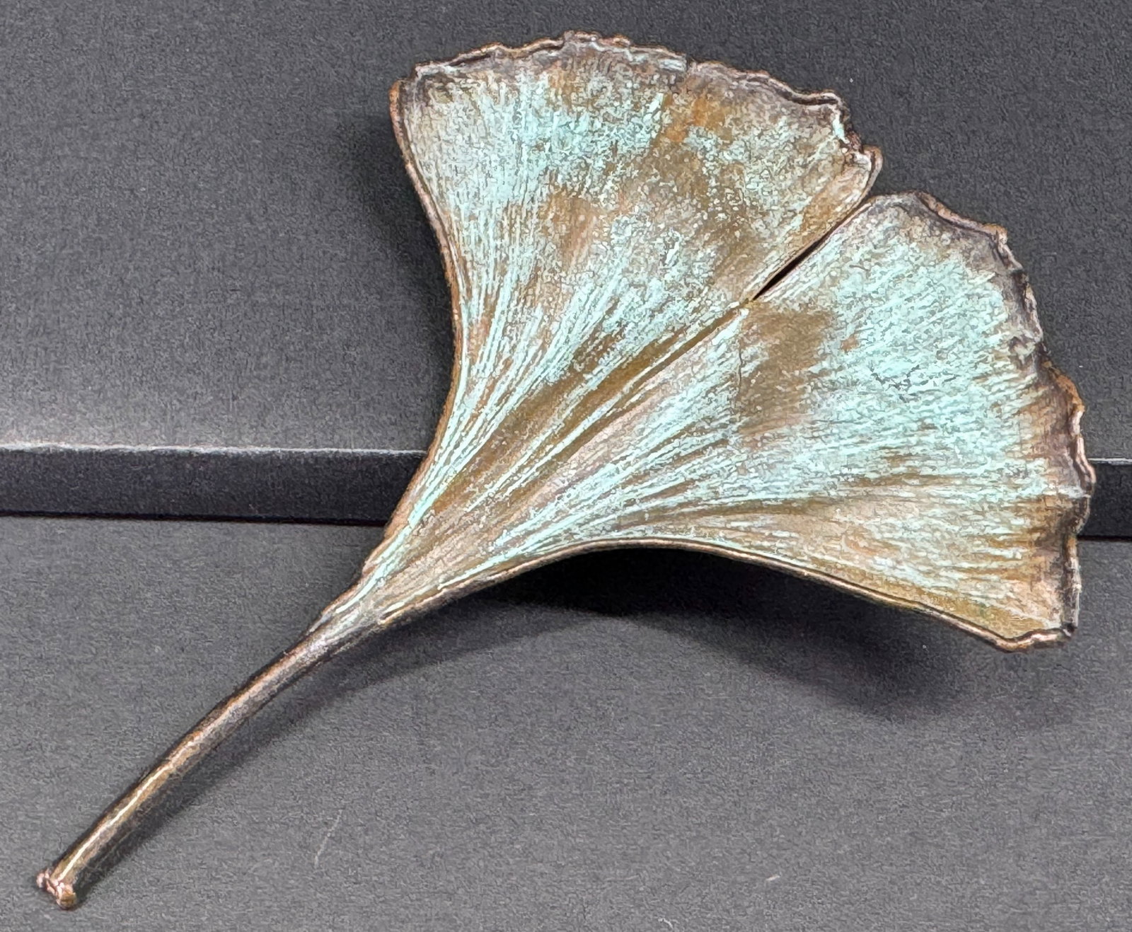 Nature”s Creations plated with copper real Ginkgo Leaf pin / pendant.: Nature”s Creations plated with copper real Ginkgo Leaf pin / pendant. Marked. Greenish patina on the front. For measures please refer to the pictures taken with a measuring tape. Weight: 12 Gram