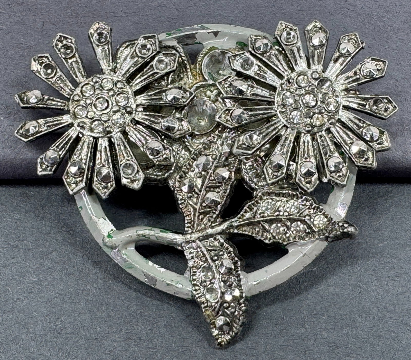 Vintage art deco marcasites & rhinestones flowers and leaves pot metal pin brooch: Vintage art deco marcasites and clear rhinestones flowers and leaves traces of painting silvertone pot metal pin brooch. Marked ROC . For measures please refer to the pictures taken with a measuring t