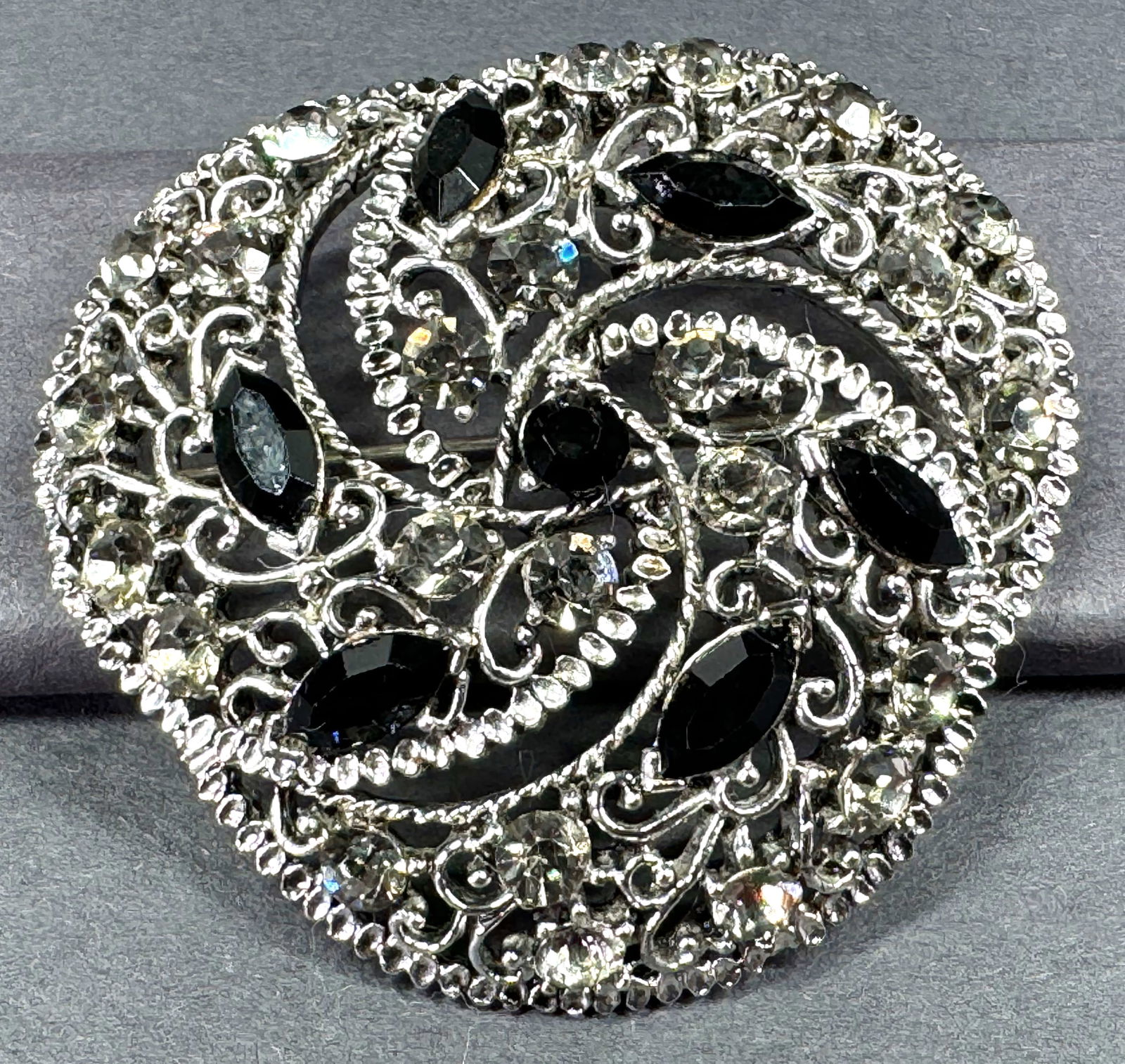 Vintage black & gray crystals filigree silvertone metal big pin brooch.: Vintage black & gray crystals filigree silvertone metal big pin brooch. Unmarked. For measures please refer to the pictures taken with a measuring tape. Weight: 25 Grams . This is a NO RESERVE AUCTION