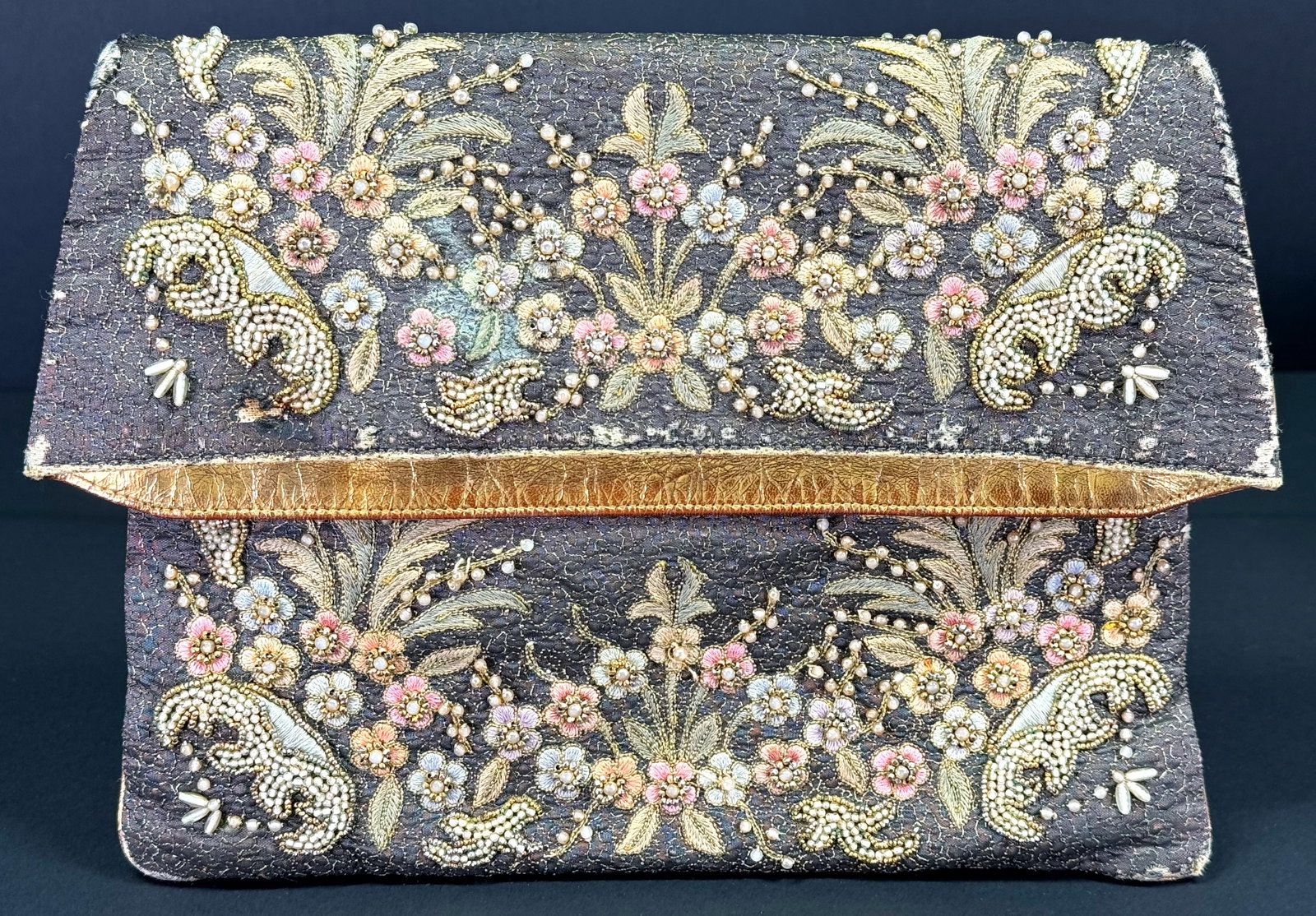 Vintage Marketa Rio de Janeiro embroidery and beaded metallic fabric folding clutch purse: Vintage Marketa Rio de Janeiro embroidery and beaded flowers and leaves metallic fabric folding clutch purse. Fabric label. Genuine golden leather rim. The interior in fabric with 2 pockets. For measu