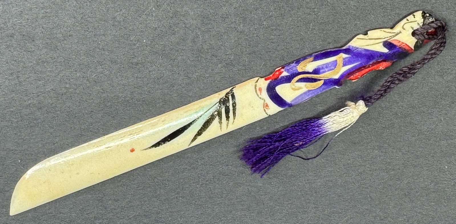 Vintage Japanese carved and painted figural handle bone letter opener with tassel.: Vintage Japanese carved and painted figural handle bone letter opener with tassel. Marked Made in Japan. For measures please refer to the pictures taken with a measuring tape. Weight: 6 Grams. This is