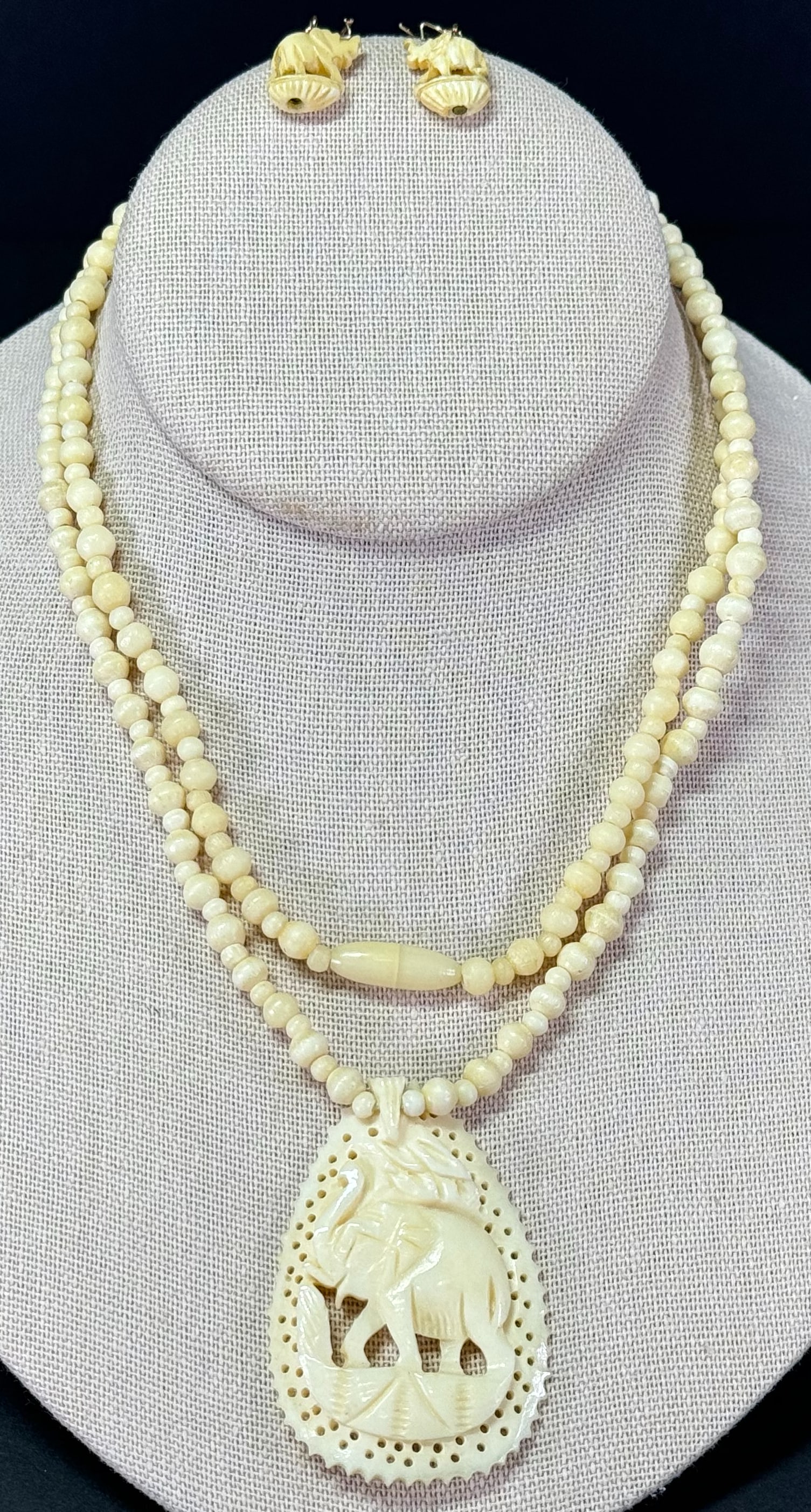 Vintage carved bone elephant medallion beaded necklace and hook earrings.: Vintage carved bone elephant medallion beaded necklace and hook earrings. Unmarked. For measures please refer to the pictures taken with a measuring tape. Weight: 27 Grams. This is a NO RESERVE AUCTIO