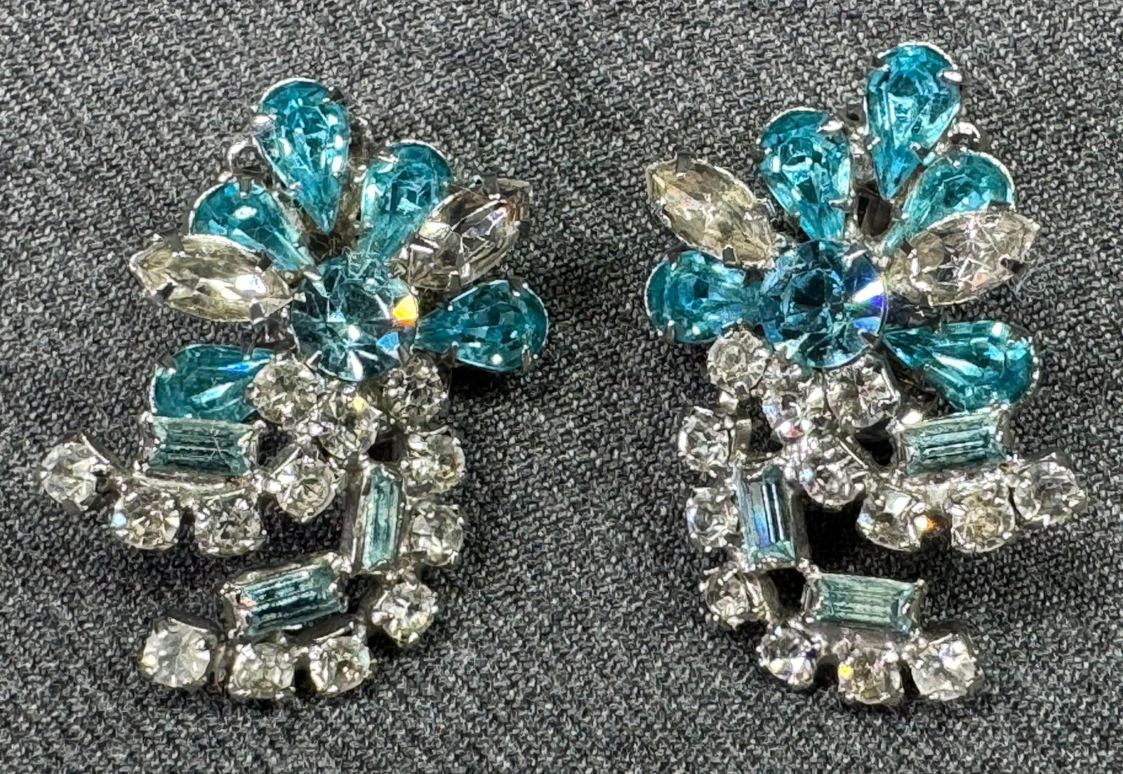 Vintage Kramer clear & turquoise crystals silvertone metal flower clip on earrings: Vintage Kramer clear & turquoise crystals silvertone metal flower clip on earrings.Marked. For measures please refer to the pictures taken with a measuring tape. Weight: 15 Grams. This is a NO RESERVE
