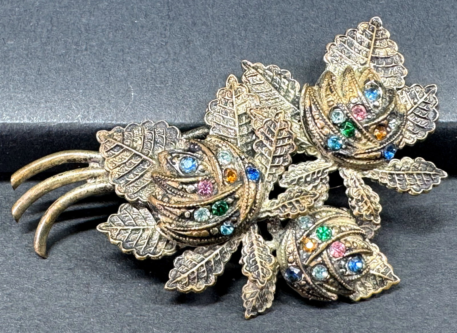Vintage Czech color rhinestones goldtone metal flower & leaves bouquet pin brooch.: Vintage Czech color rhinestones goldtone metal flower & leaves bouquet pin brooch. Unmarked For measures please refer to the pictures taken with a measuring tape. Weight: 7 Grams. This is a NO RESERVE