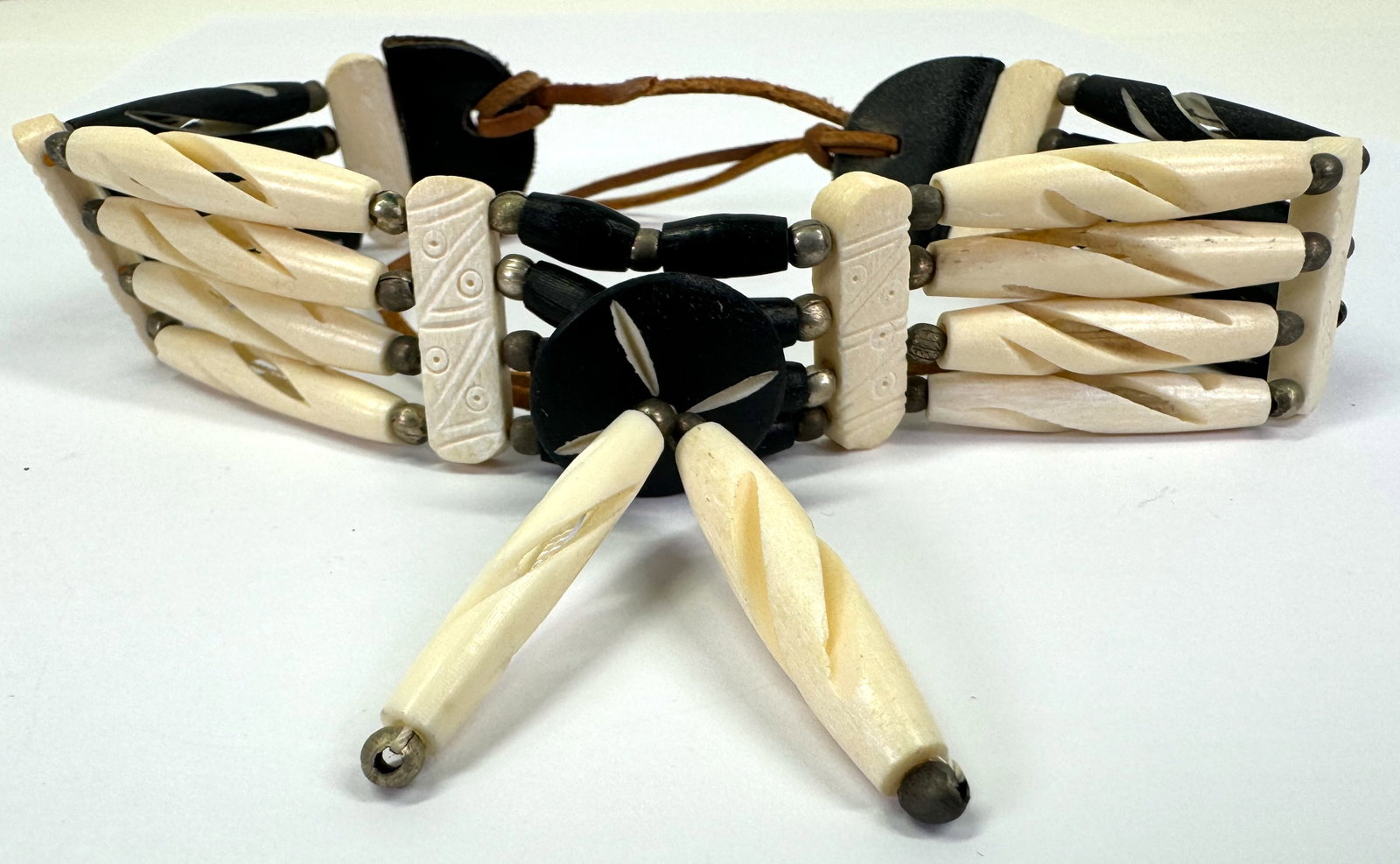 Native american style bone pipeline, silvertone metal and leather strap choker.: Native american style bone pipeline, silvertone metal and leather strap choker. Unmarked . . For measures please refer to the pictures taken with a measuring tape. Weight: 45 Grams. This is a NO RESER