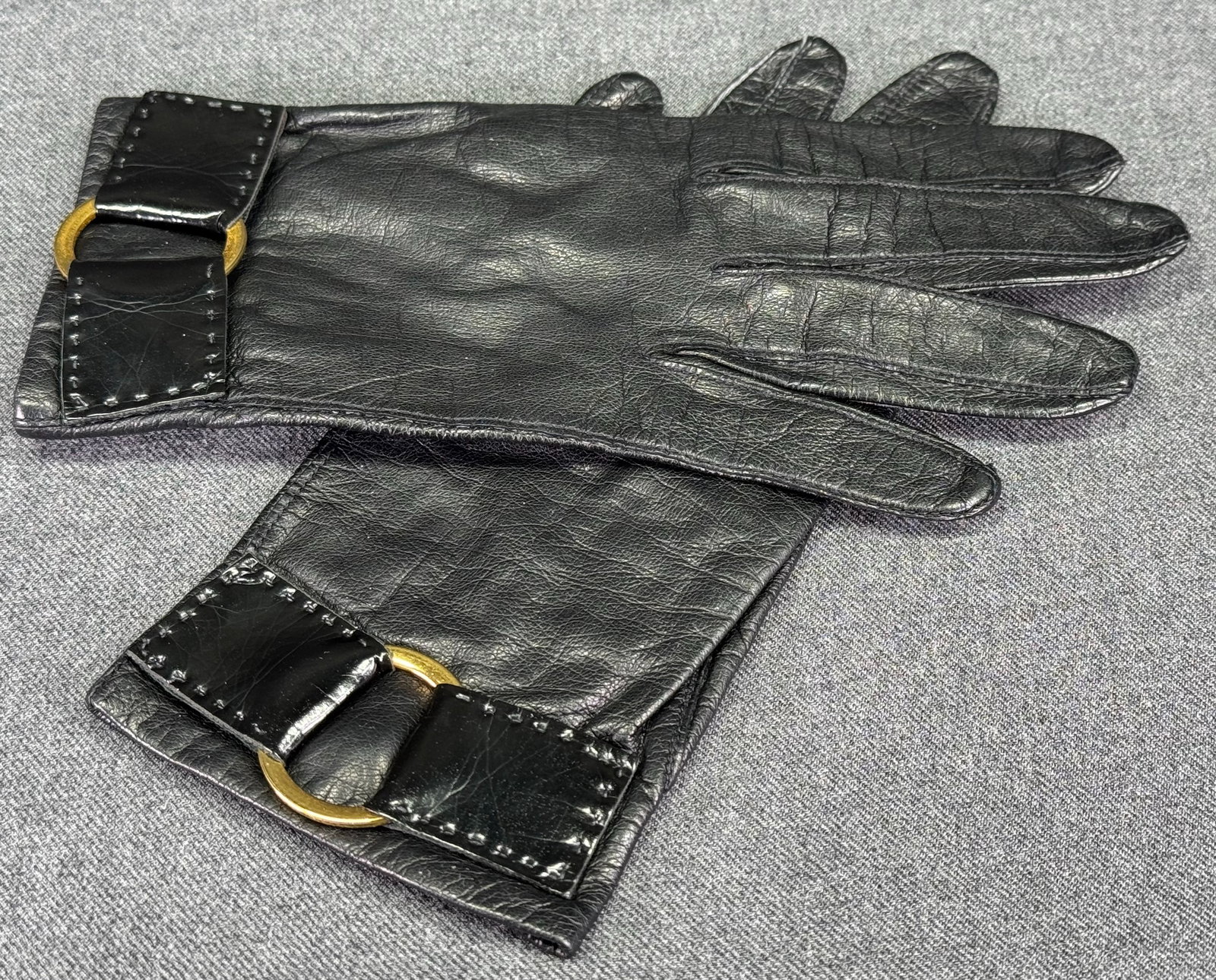 Vintage French lined in silk, goldtone metal ring black leather gloves: Vintage French lined in silk, goldtone metal ring ornate, black leather gloves. glass buttons. 6 1/2. Label Made in France, 100% silk , 6 1/2. For measures please refer to the pictures taken with a me