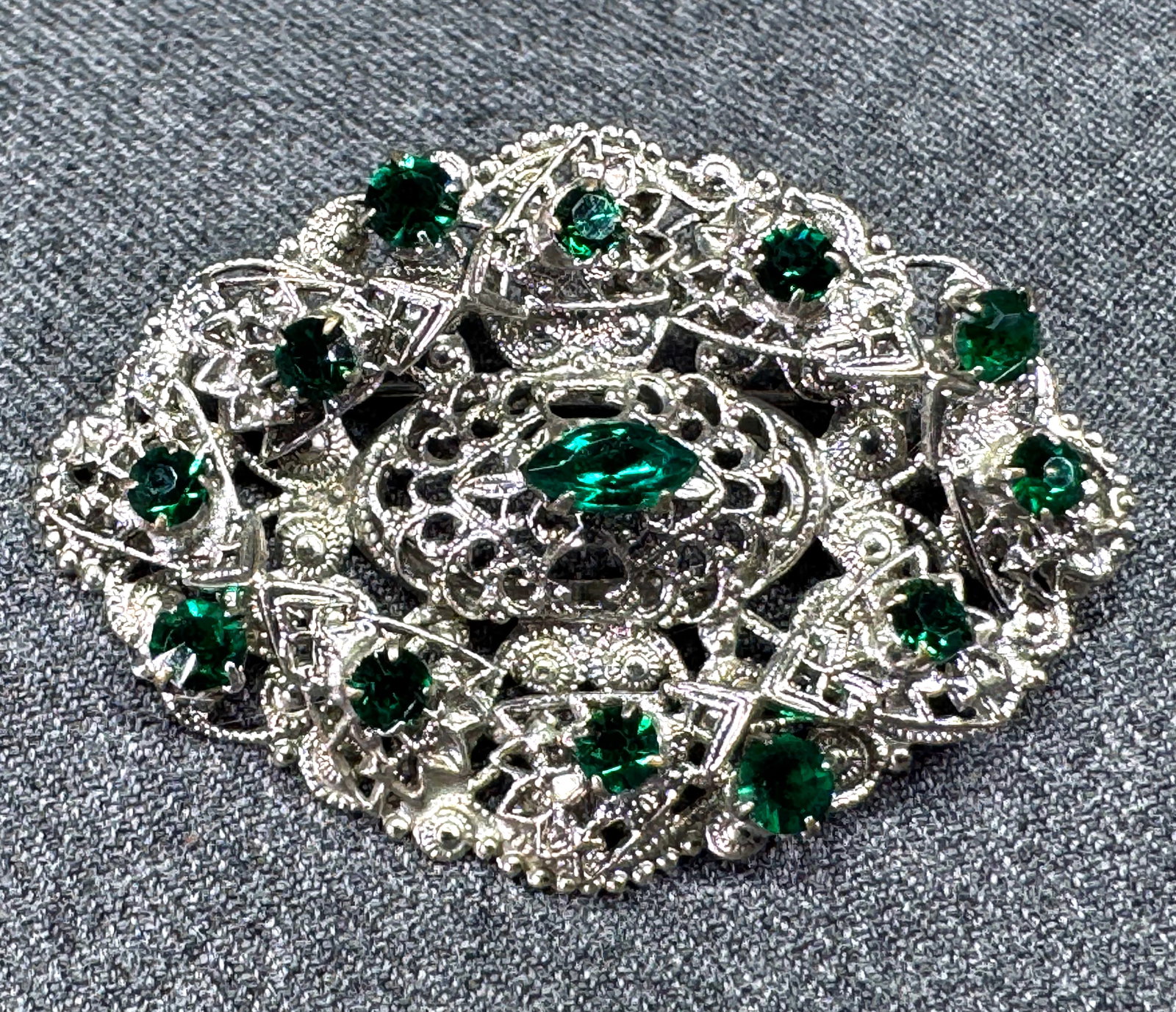 Vintage Czech green crystals filigree silvertone pin brooch: Vintage Czech green crystals filigree silvertone pin brooch. Um,arked. For measures please refer to the pictures taken with a measuring tape. Weight: 10 Grams. This is a NO RESERVE AUCTION: there are 