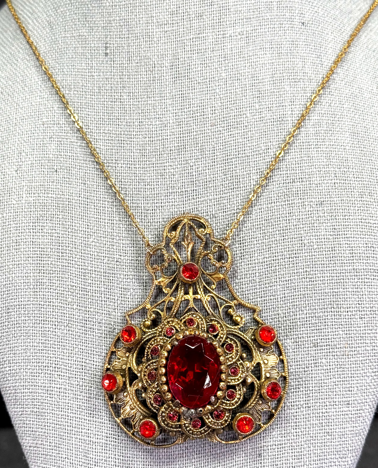 Antique Czech red rystal and rhinestones filigree goldtone metal medallion with chain necklace: Antique Czech red rystal and rhinestones filigree goldtone metal medallion with chain necklace. Unmarked. For measures please refer to the pictures taken with a measuring tape. Weight: 22 Grams. This 