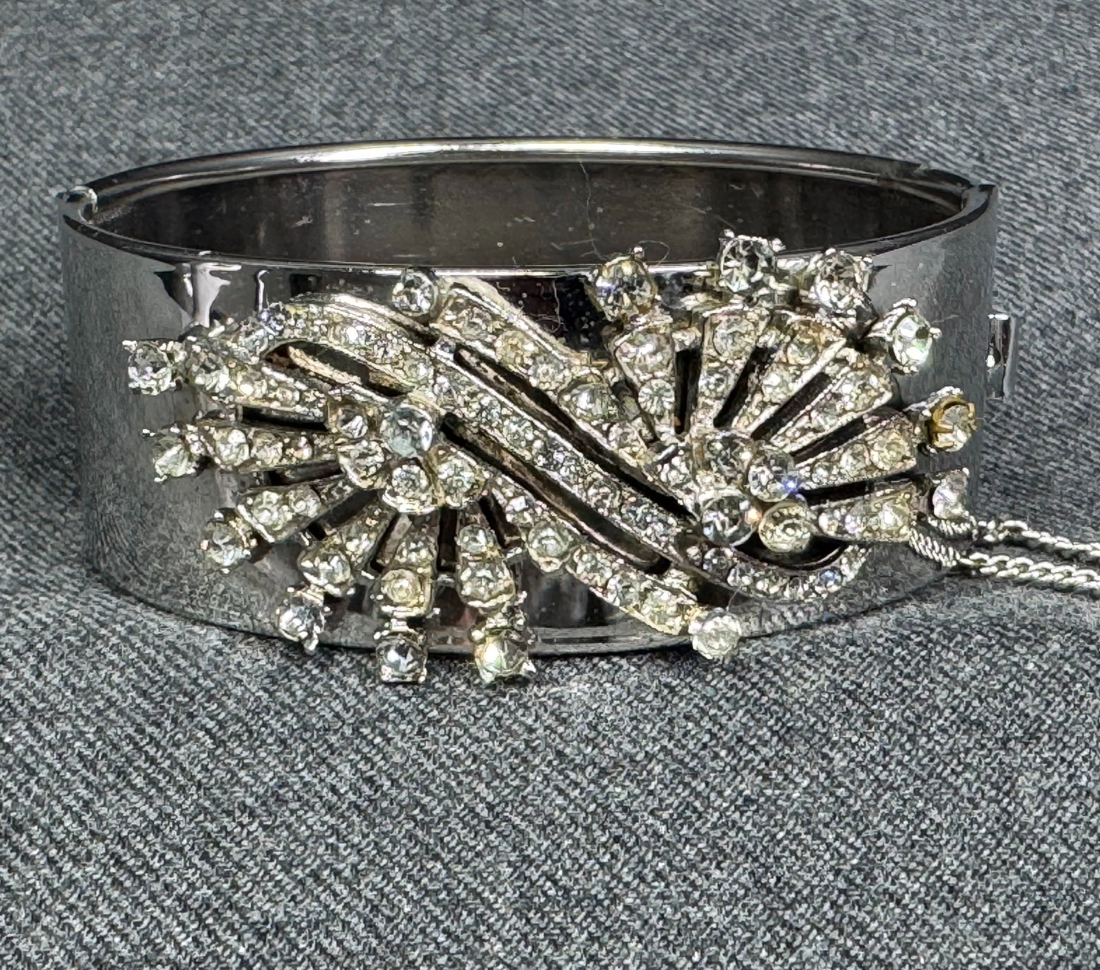 Vintage clear rhinestones filigree applique silvertone metal hinged bracelet: Vintage clear rhinestones filigree applique silvertone metal hinged bracelet. Security chain. Unmarked. For measures please refer to the pictures taken with a measuring tape. Weight: 44 Grams. This is