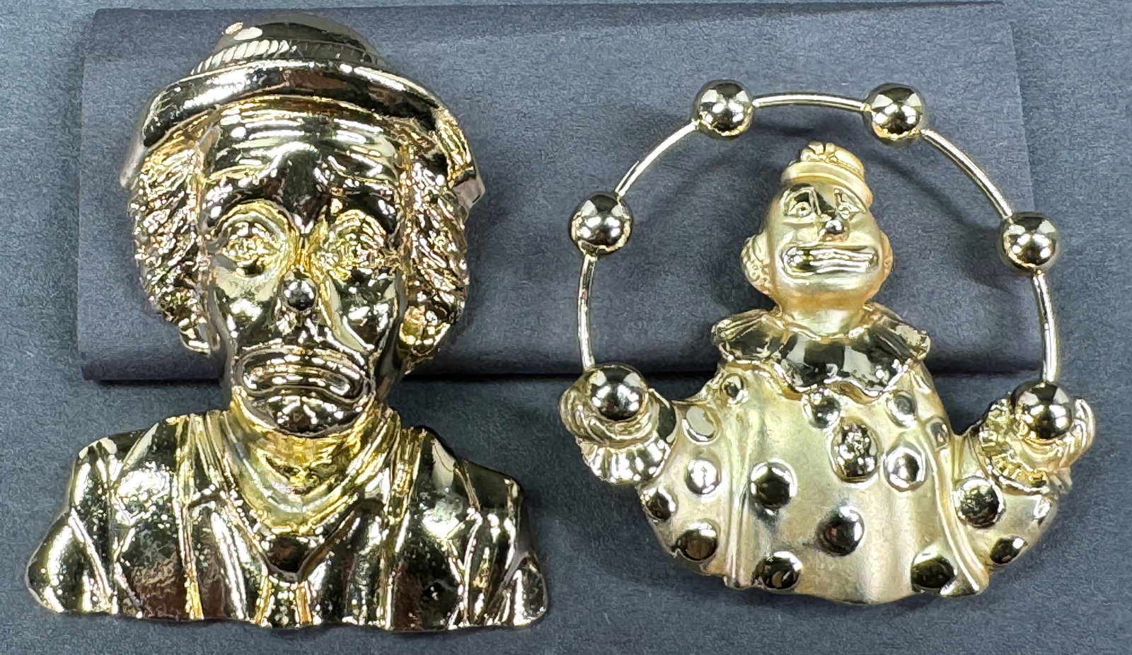 Vintage goldtone metal clown large pin brooches. One is signed AJC: Vintage goldtone metal clown large pin brooches. One is signed AJC and the other one is unmarked. For measures please refer to the pictures taken with a measuring tape. Weight: 68 Grams. This is a NO 
