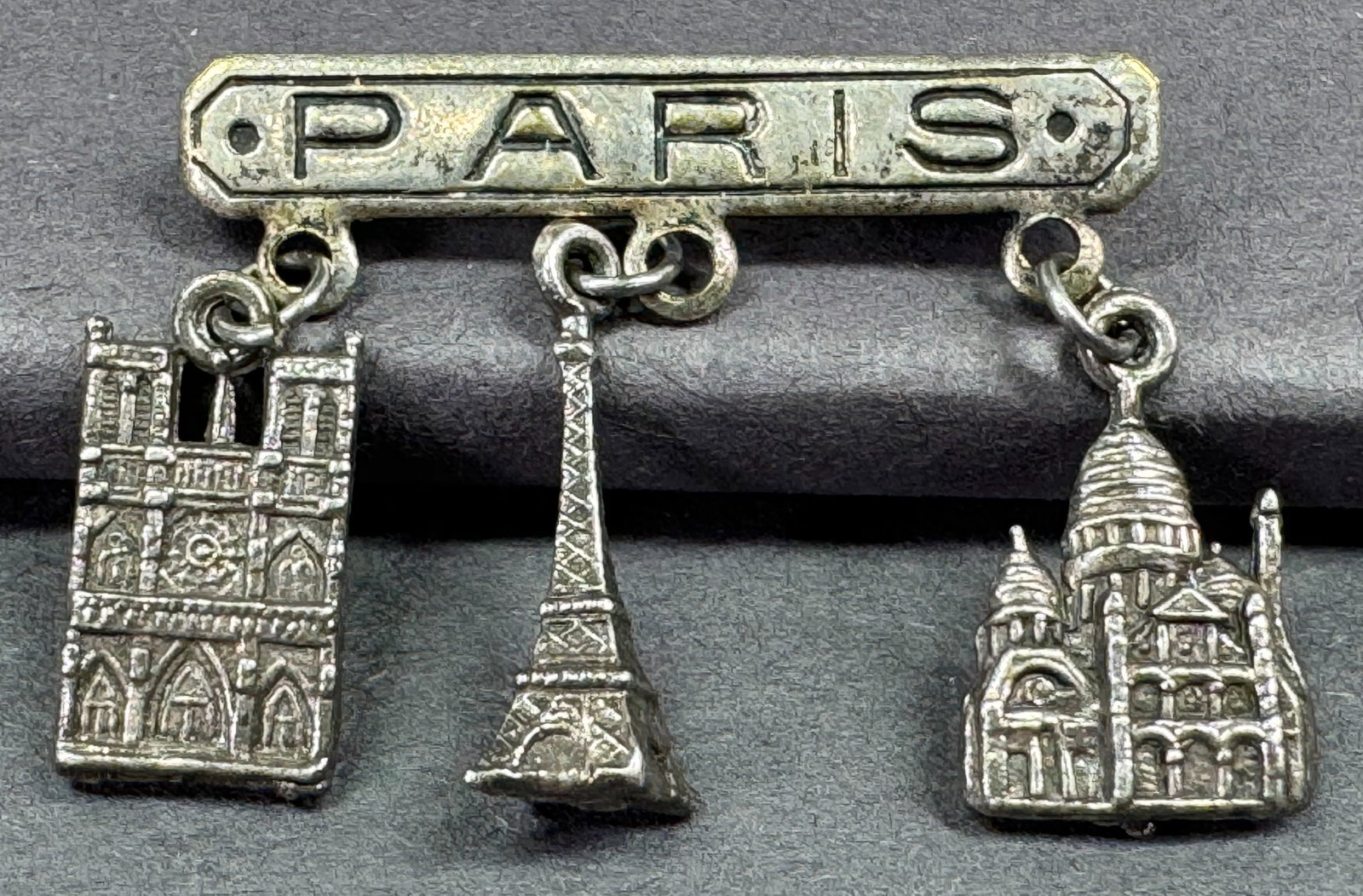 Vintage Eiffel Tower, Notre Dame & Montmartre dangles Paris silvertone metal pin brooch: Vintage Eiffel Tower, Notre Dame & Montmartre dangles Paris silvertone metal pin brooch Unmarked. For measures please refer to the pictures taken with a measuring tape. Weight: 2 Grams. This is a NO R