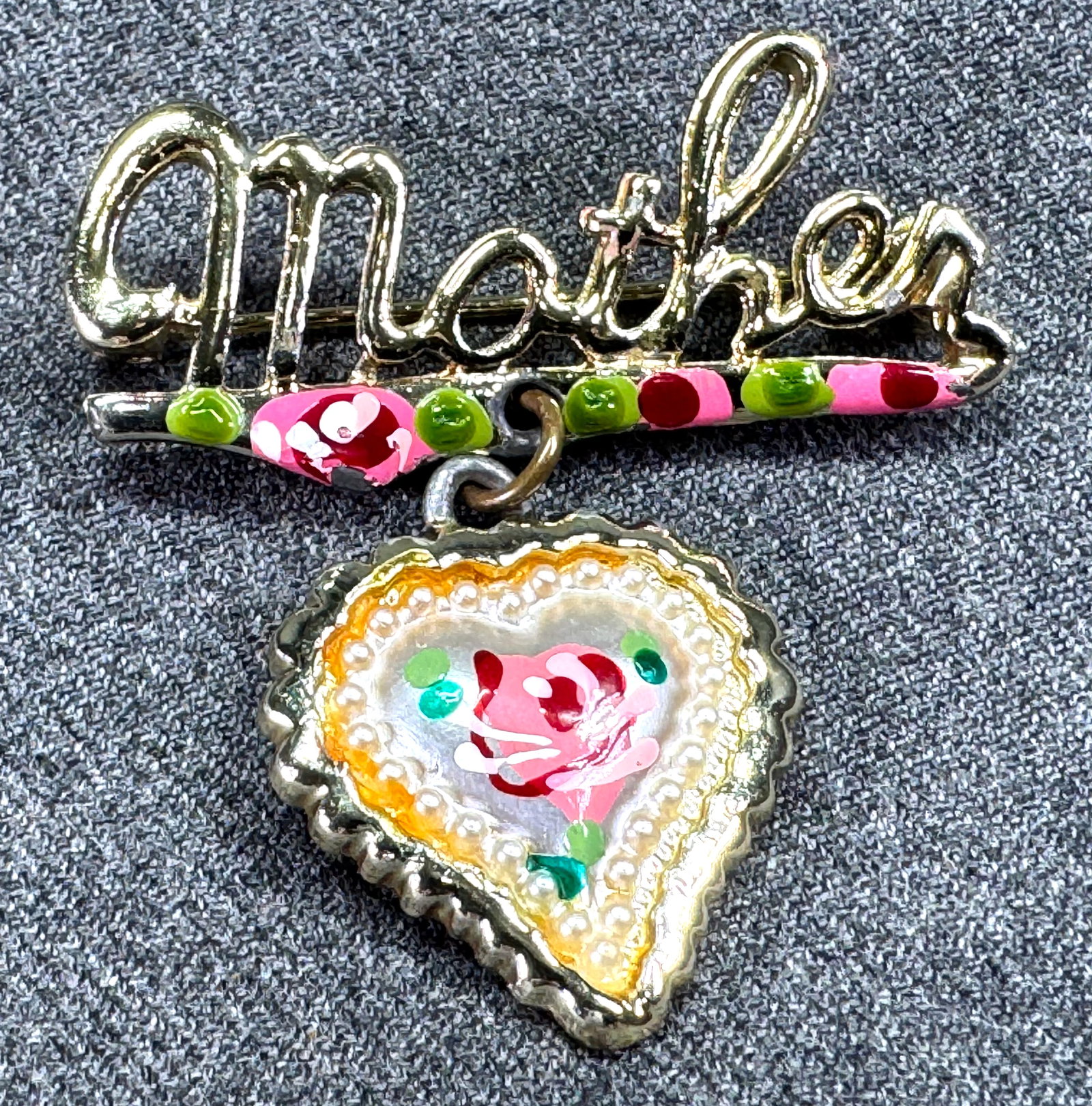 Vintage enameled goldtone metal dangling heart Mother pin brooch: Vintage enameled goldtone metal dangling heart Mother pin brooch. Unmarked. For measures please refer to the pictures taken with a measuring tape. Weight: 4.67 Grams. This is a NO RESERVE AUCTION: the