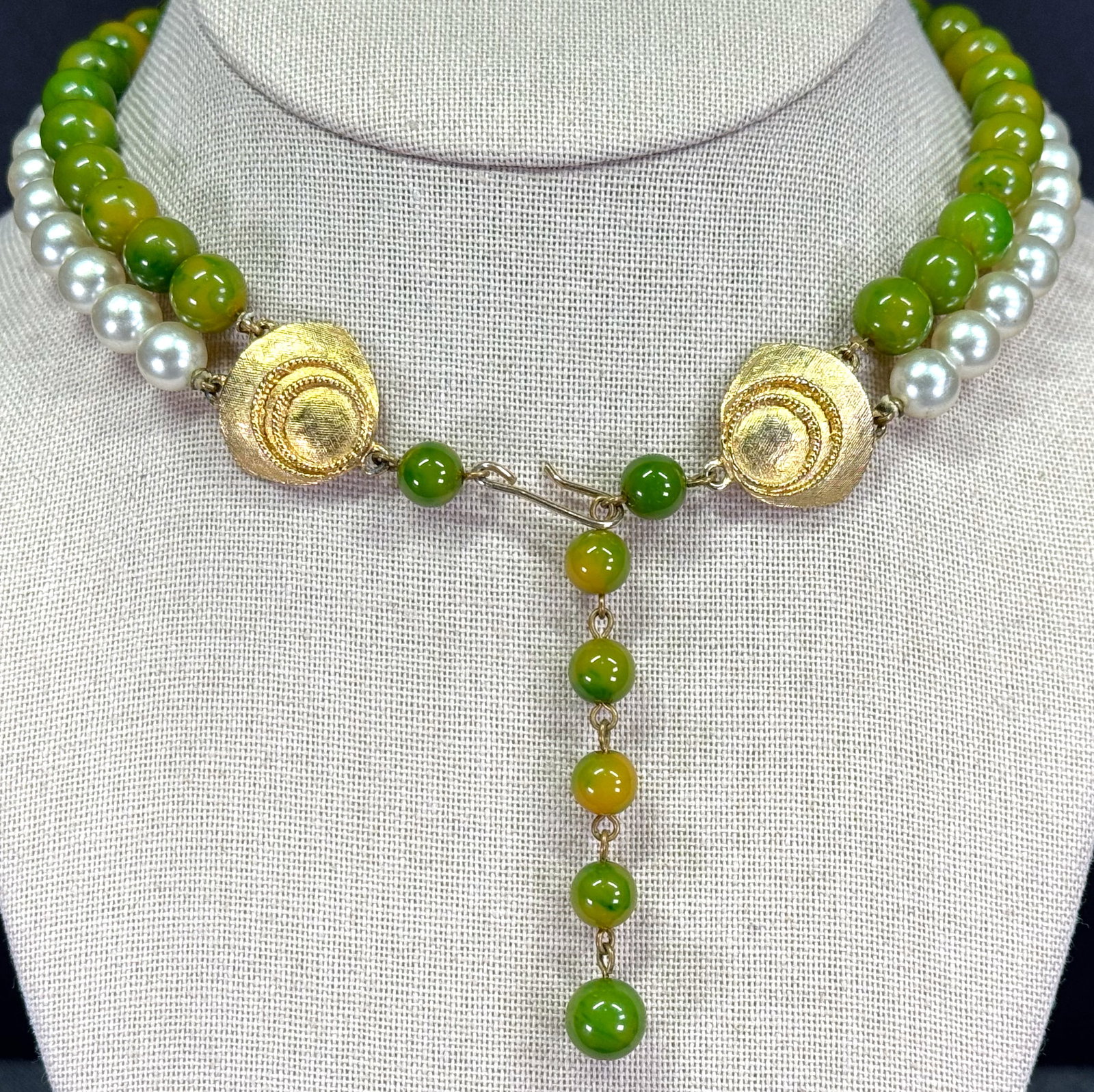 Vintage green bakelite like plastic and pearly beads 2 strands choker necklace: Vintage green bakelite like plastic and pearly beads 2 strands choker necklace.Goldtone metal clasp. Unmarked. For measures please refer to the pictures taken with a measuring tape. Weight: 38 Grams. 
