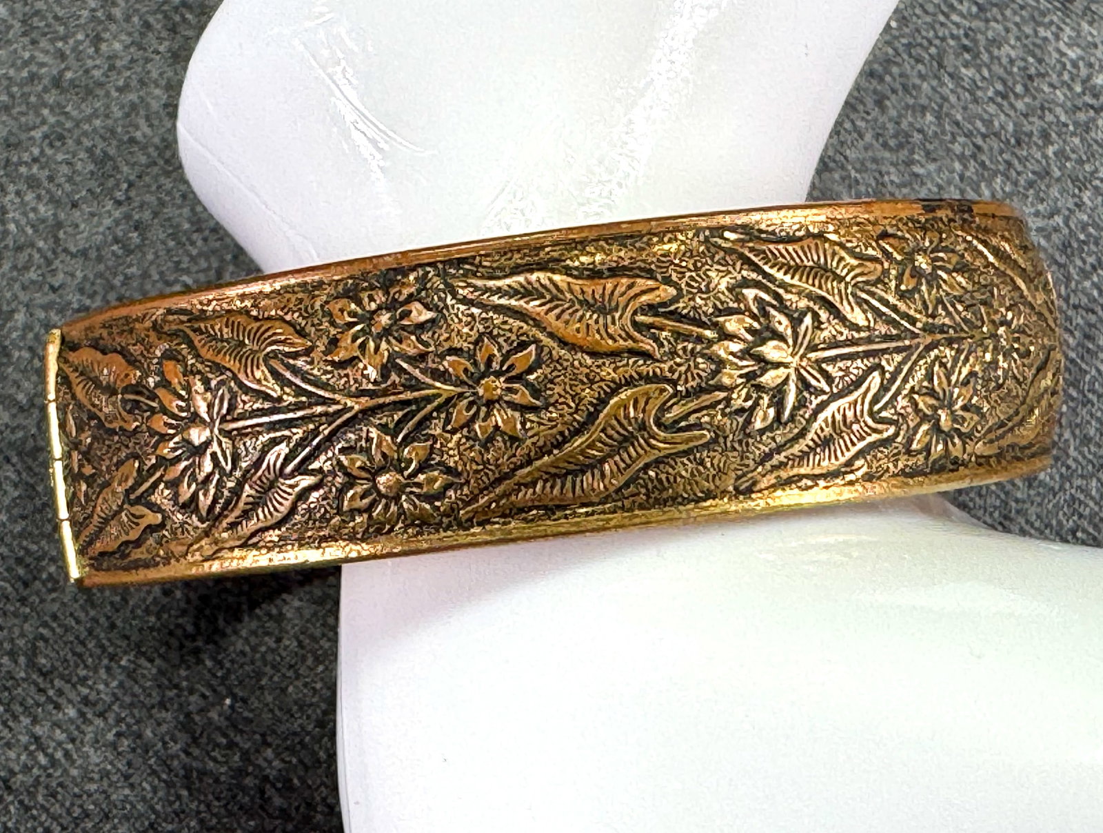 Antique black accents goldtone metal flowers and leaves hinged bracelet: Antique black accents goldtone metal flowers and leaves hinged bracelet. Security chain. Unmarked. For measures please refer to the pictures taken with a measuring tape. Weight:22 Grams. IN HOUSE Esti