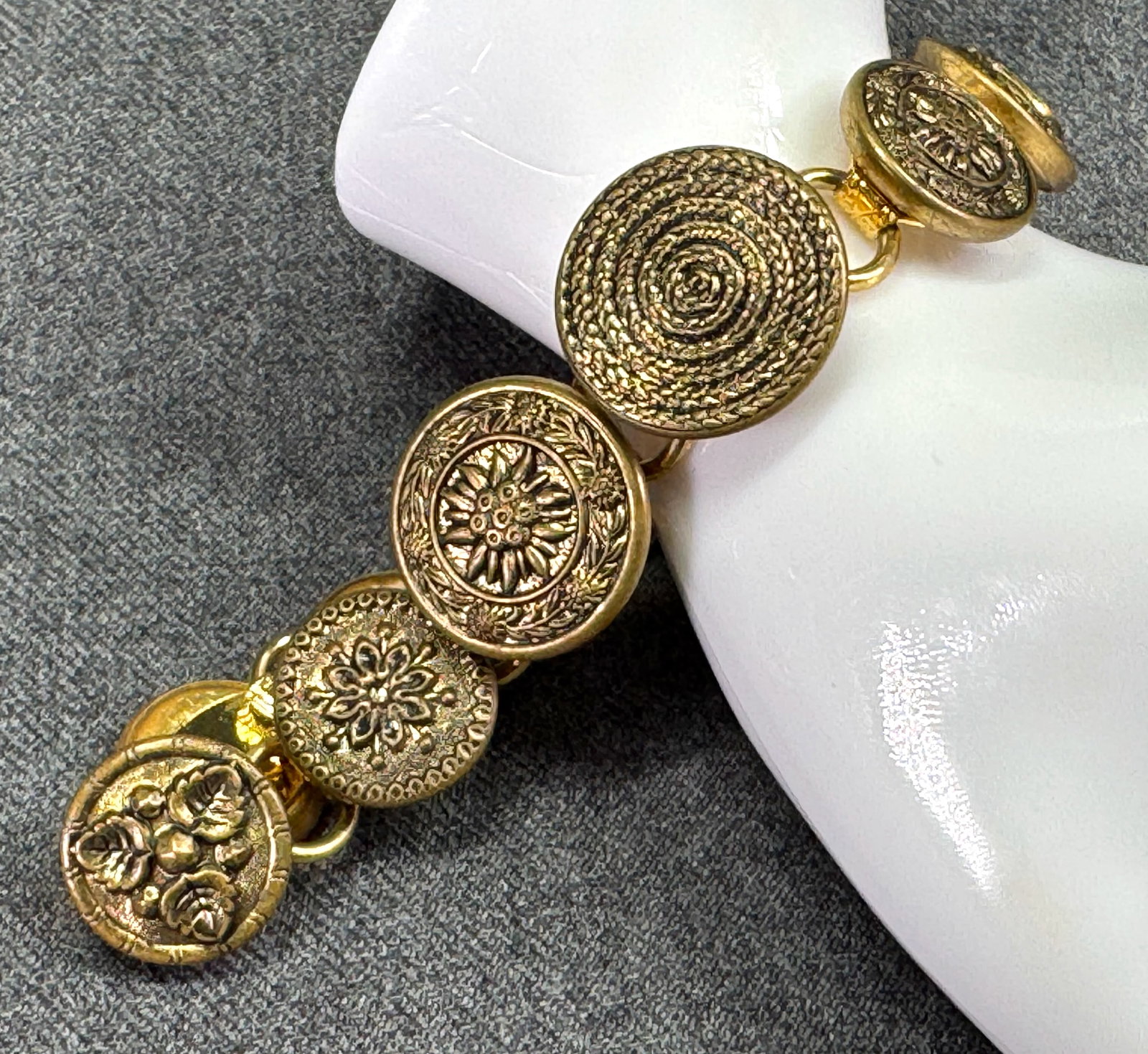 Vintage artsy crafted with antique buttons goldtone metal bracelet: Vintage artsy crafted with antique buttons goldtone metal bracelet. Unmarked. For measures please refer to the pictures taken with a measuring tape. Weight: 26 Grams. IN HOUSE Estimated* shipping and 