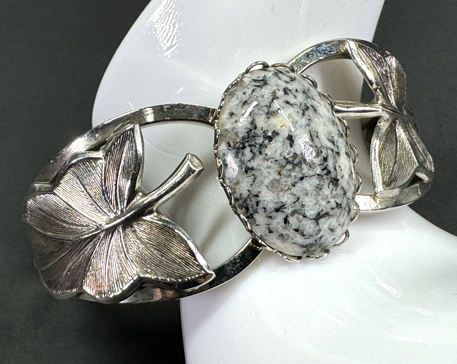 Vintage Marbled gray stone cab silvertone metal leaves hinged clamper bracelet.: Vintage Marbled gray stone cab silvertone metal leaves hinged clamper bracelet. Unmarked. For measures please refer to the pictures taken with a measuring tape. Weight: 31 Grams. This is a NO RESERVE 