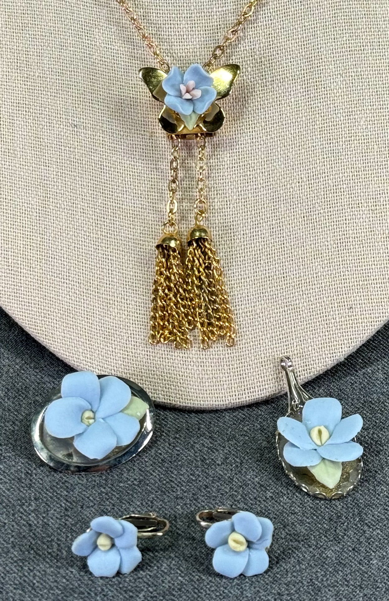 Vintage skyblue dough flower sliding lariat necklace & pendant, brooch & earrings set .: Vintage skyblue dough flower goldstone metal medallion sliding lariat chain strap necklace with tassel & pendant, pin brooch & clip on earrings silver tone metal set . the set us unmarked the sliding 