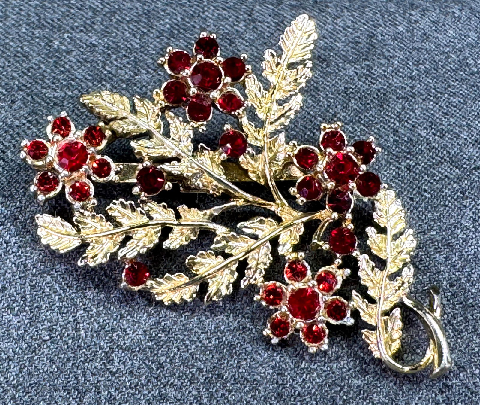 Vintage Coro style red rhinestones goldtone metal flowers bouquet pin brooch: Vintage Coro style red rhinestones goldtone metal flowers bouquet pin brooch. Unmarked. For measures please refer to the pictures taken with a measuring tape. Weight: 20 Grams. IN HOUSE Estimated* shi