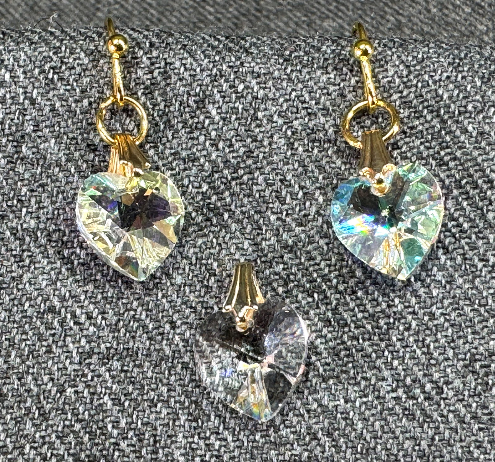 AB crystal goldtone hook heart dangle earrings and clear pendant: AB crystal heart dangle goldtone hook earrings and clear crystal heart pendant. For measures please refer to the pictures taken with a measuring tape. Weight: 3 Grams IN HOUSE Estimated* shipping and 