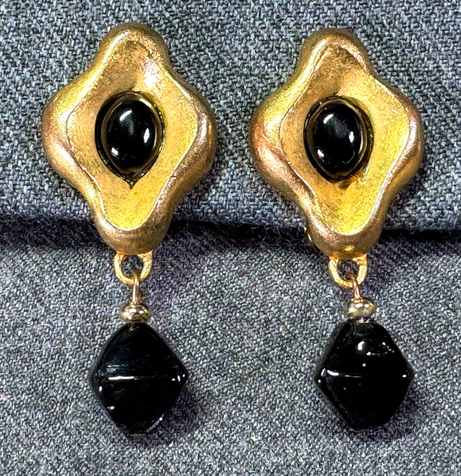 Vintage 80s black glass cab & dangle goldtone metal clip on earrings: Vintage 80s black glass cab & dangle goldtone metal clip on earrings. Unmarked. For measures please refer to the picture taken with a measuring tape. Weight: 20 Grams. IN HOUSE Estimated* shipping and