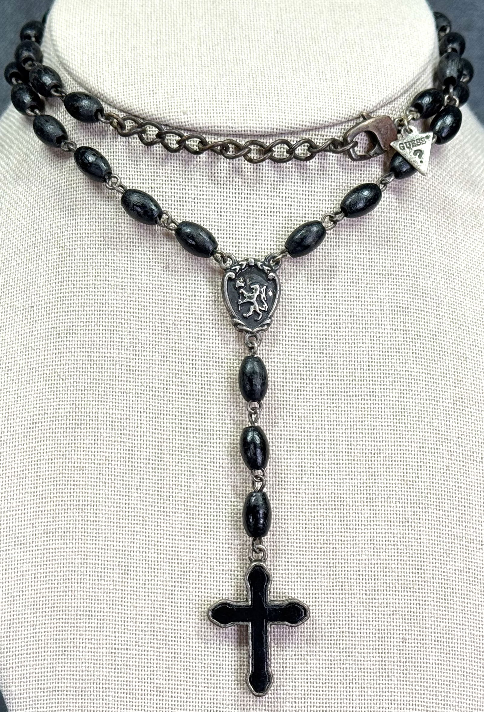 Vintage 90s Guess black wooden & metal cross rosary style necklace: Vintage 90s Guess black wooden & metal cross rosary style necklace. Metal label. For measures please refer to the pictures taken with a measuring tape . Weight: 16 Grams. IN HOUSE Estimated* shipping