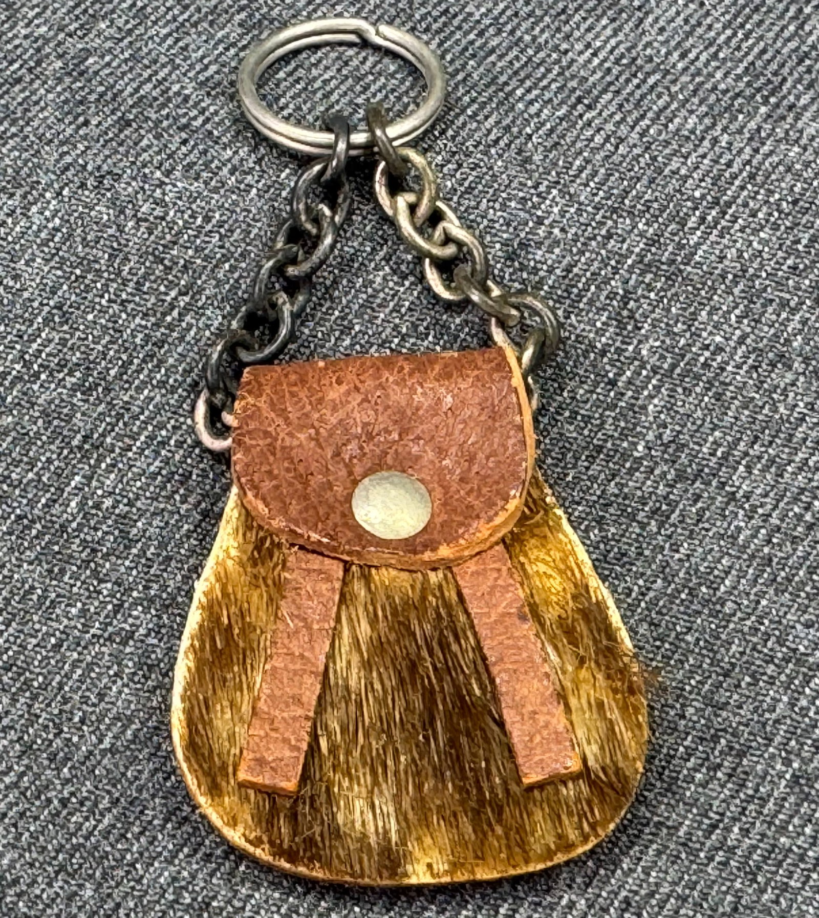 Vintage Scottish leather & hide miniature sporran shaped key ring: Vintage Scottish leather & hide miniature sporran shaped key ring. Marked. Not been made to be opened. For measures please refer to the pictures taken with a measuring tape. Weigh: 7 Grams. IN HOUSE E