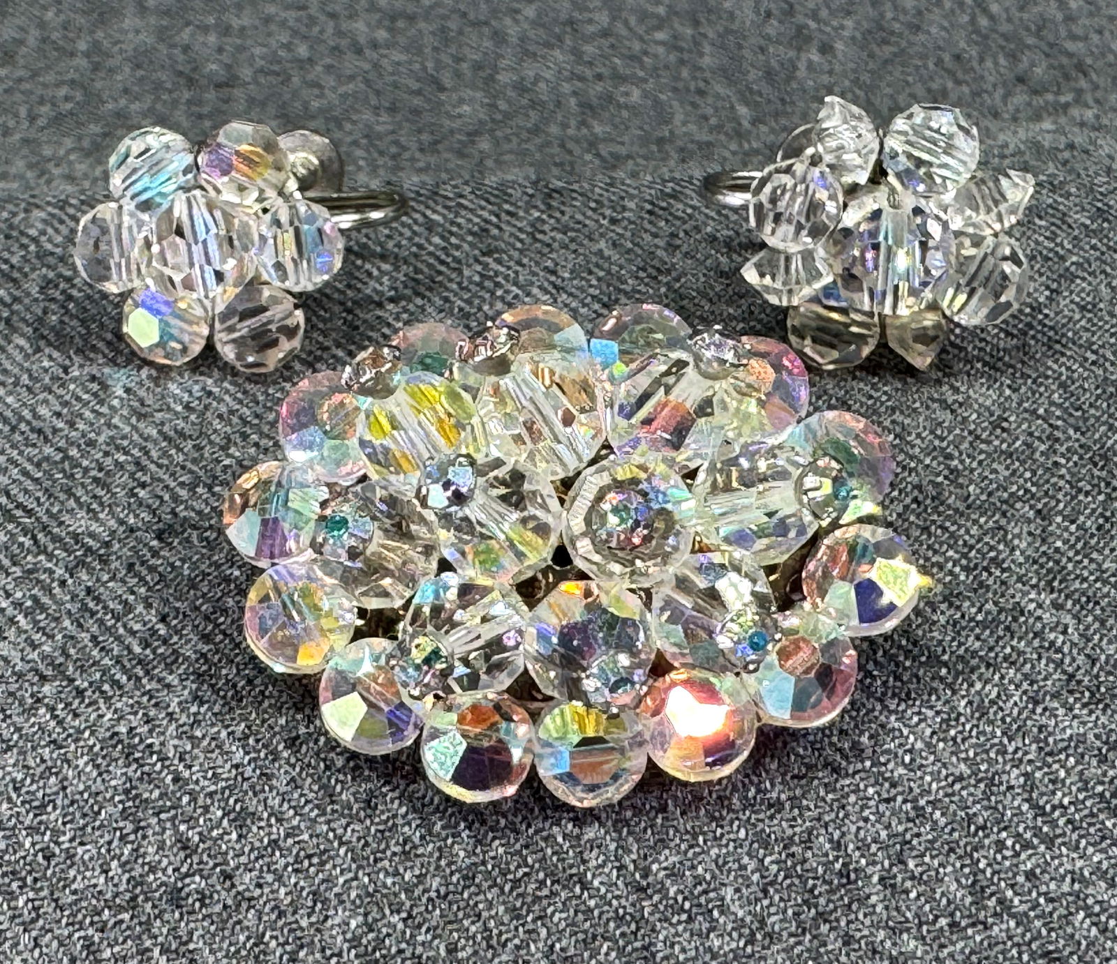 Vintage AB crystals margarita beaded goldtone oval brooch & flower screw back earrings: Vintage AB crystals margarita beaded goldtone oval brooch & flower silvertone screw back earrings. Unmarked. For measures please refer to the pictures taken with a measuring tape. Weight: 20 Grams. Th