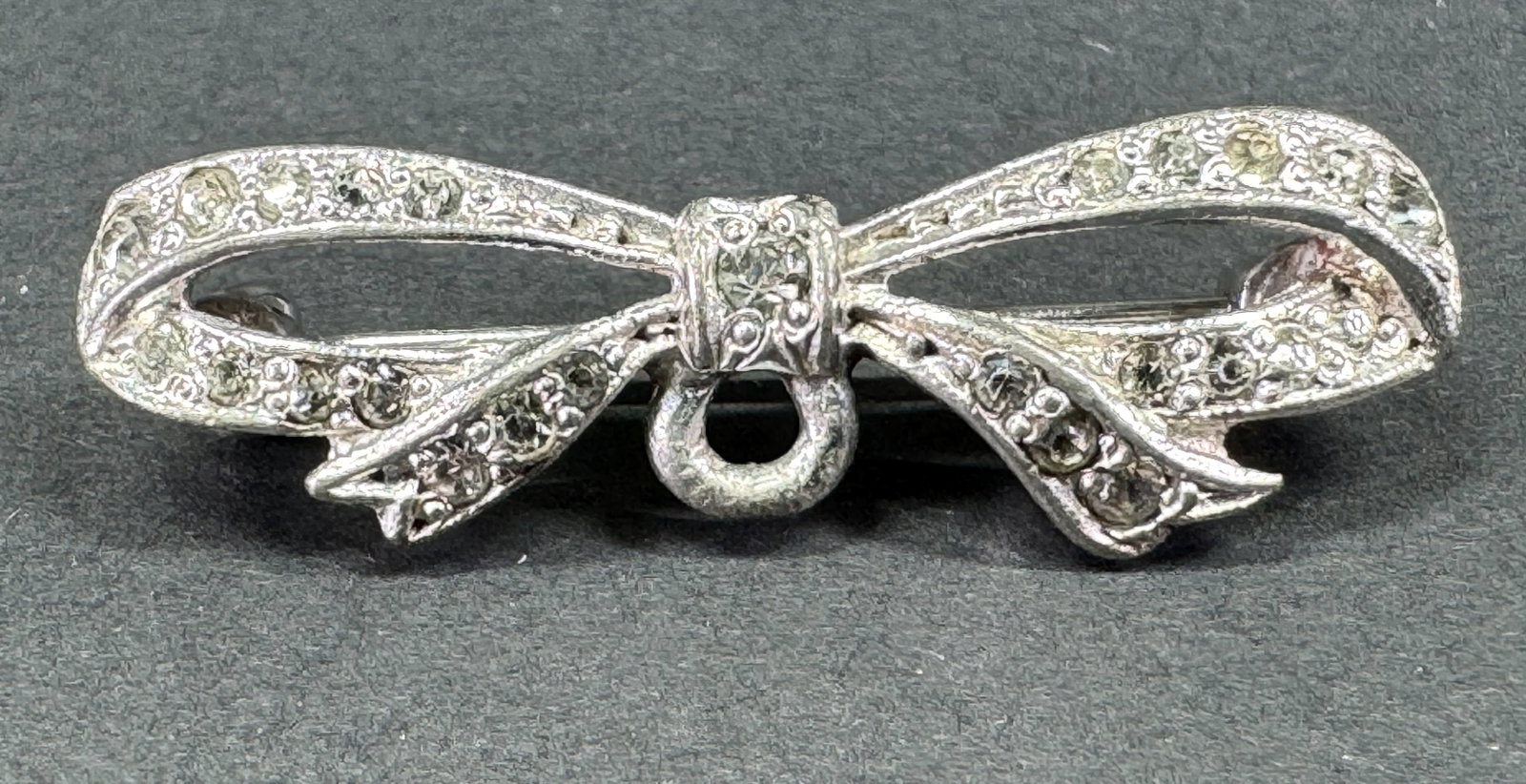 Vintage art deco clear rhinestones pot metal ring for dangle ribbons in bow pin brooch.: Vintage art deco clear rhinestones pot metal ring for dangle ribbons in bow pin brooch. Unidentified markk For measures please refer to the pictures taken with a measuring tape. Weight: 3 Grams. This 