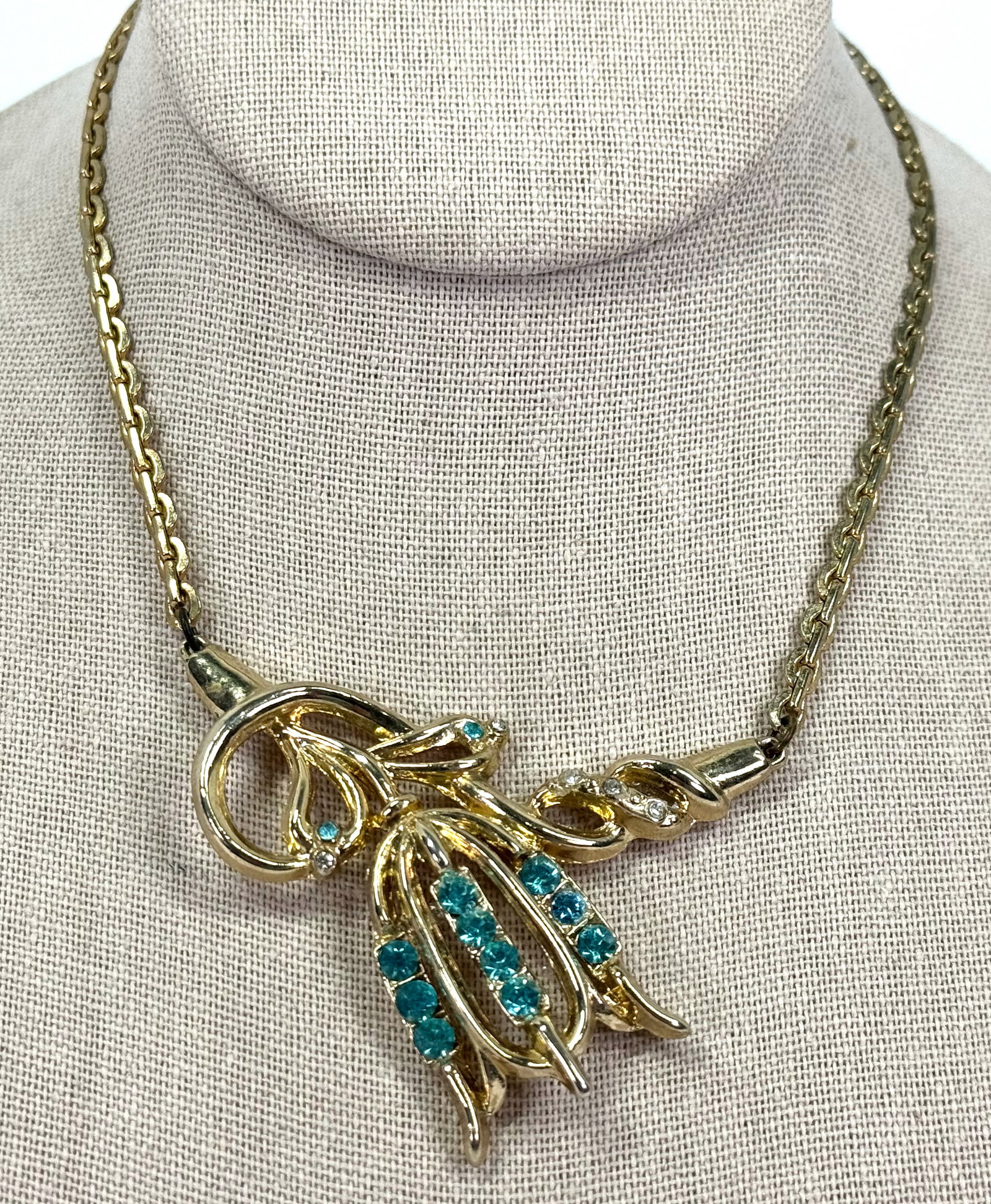 Vintage aqua & clear rhinestones tulip flower medallion goldtone collar necklace: Vintage aqua & clear rhinestones tulip flower & leaves medallion goldtone metal collar necklace. Unmarked. For measures please refer to the pictures taken with a measuring tape. Weight: 41 Grams. This