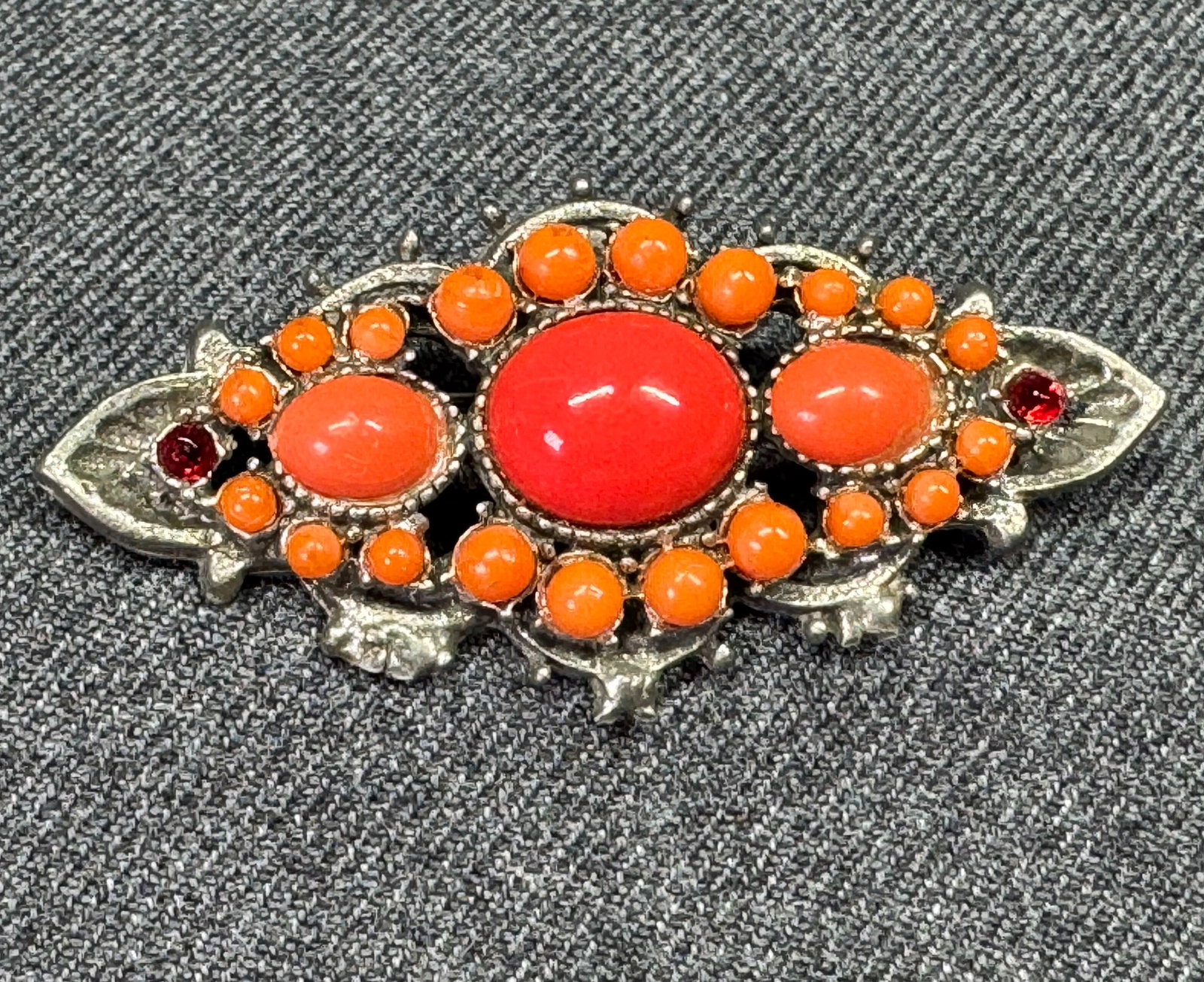 Vintage orange rhinestones, coral color glass and plastic cabs pin brooch: Vintage orange rhinestones, coral color glass and plastic cabs silvertoned metal pin brooch. Unmarked. For measures please refer to the pictures taken with a measuring tape. Weight: 9 Grams. IN HOUSE 