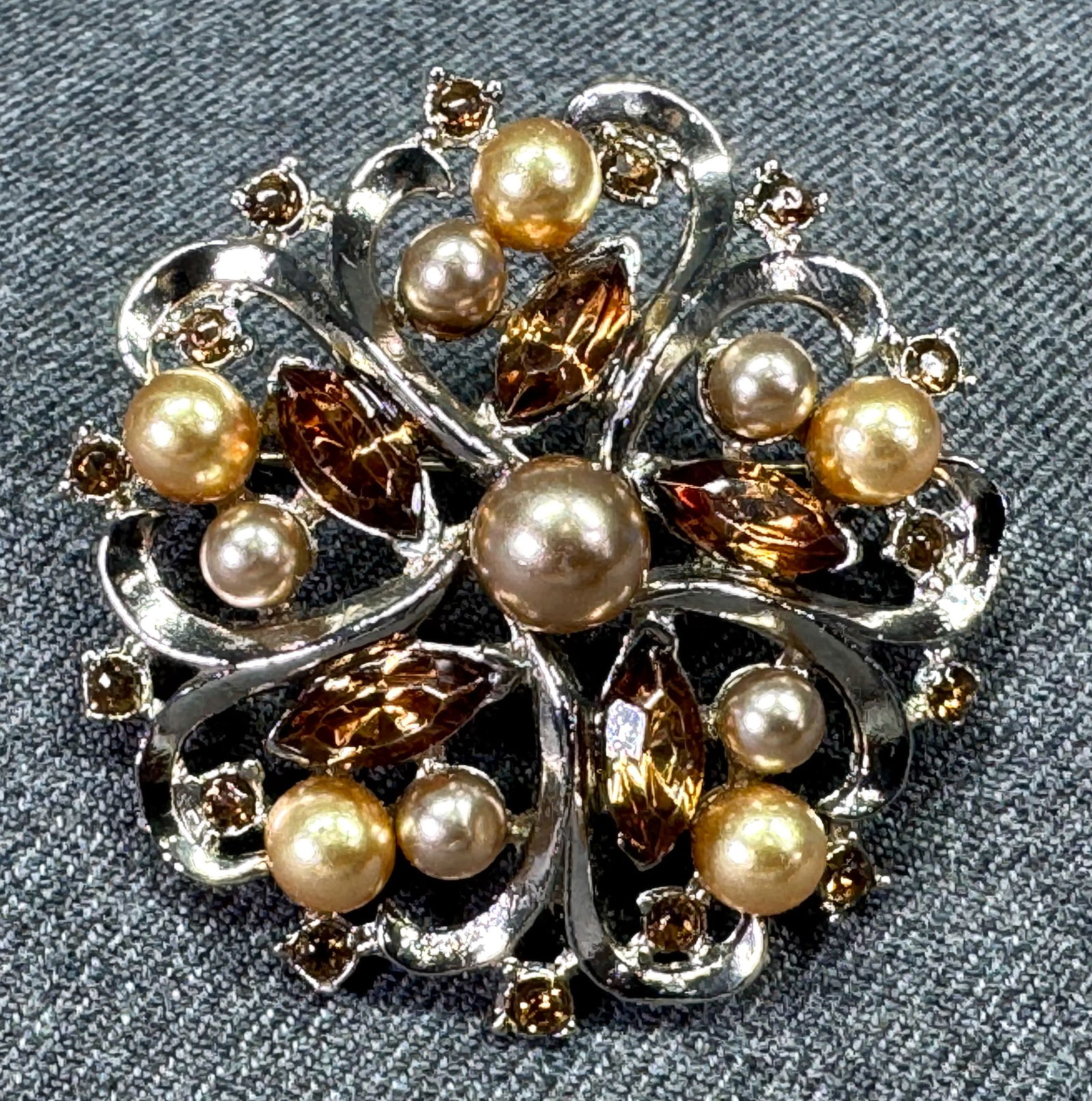Vintage Coro style pearly and brownish crystals silvertone flower rounded pin brooch.: Vintage Coro style pearly and brownish crystals silvertone flower rounded pin brooch. Unmarked. For measures please refer to the pictures taken with a measuring tape. Weight: 16 Grams IN HOUSE Estimat