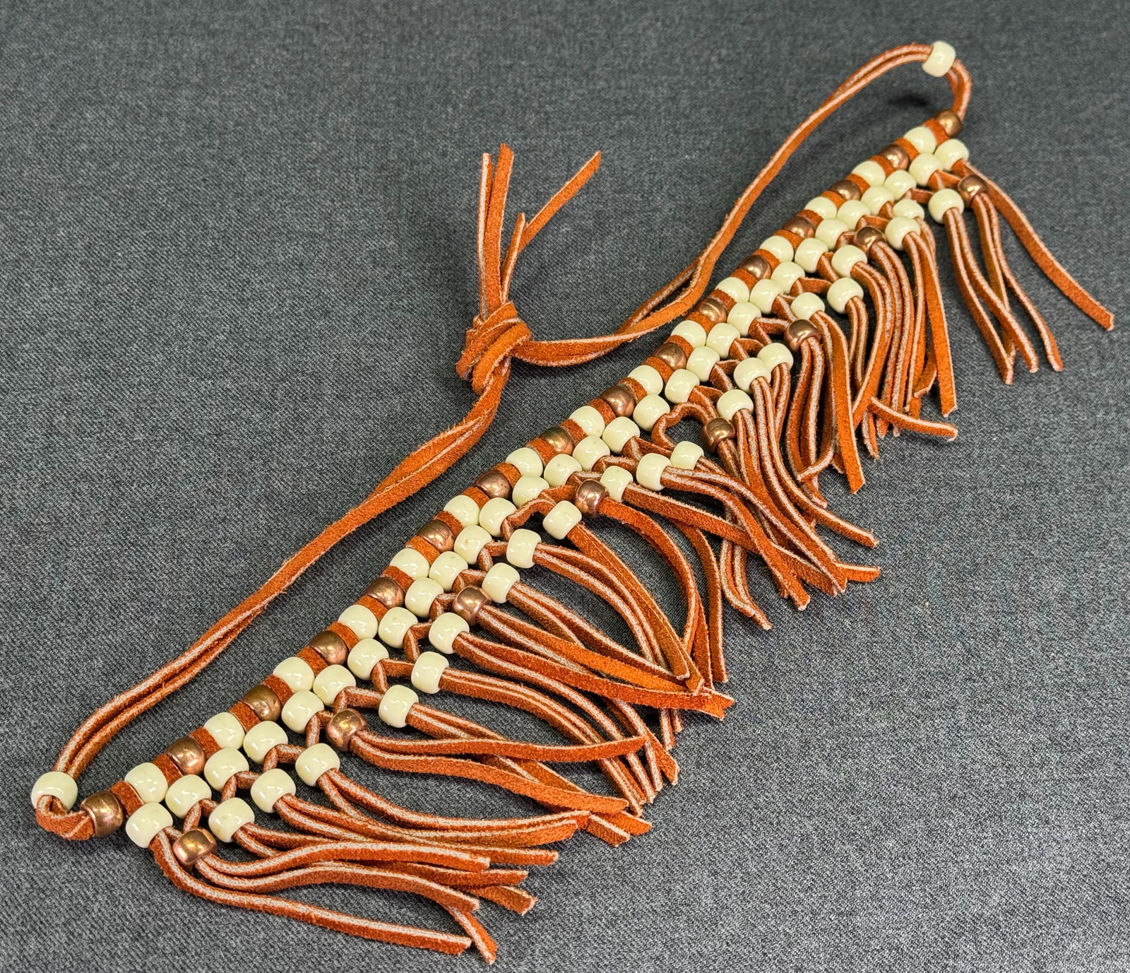 Vintage Southwestern Style creamy & copper color plastic beads genuine suede necklace with fringe: Vintage Southwestern Style creamy & copper color plastic beads genuine suede necklace with fringe. Unmarked. For measures please refer to the pictures taken with a measuring tape. Weight: 52 Grams. Th