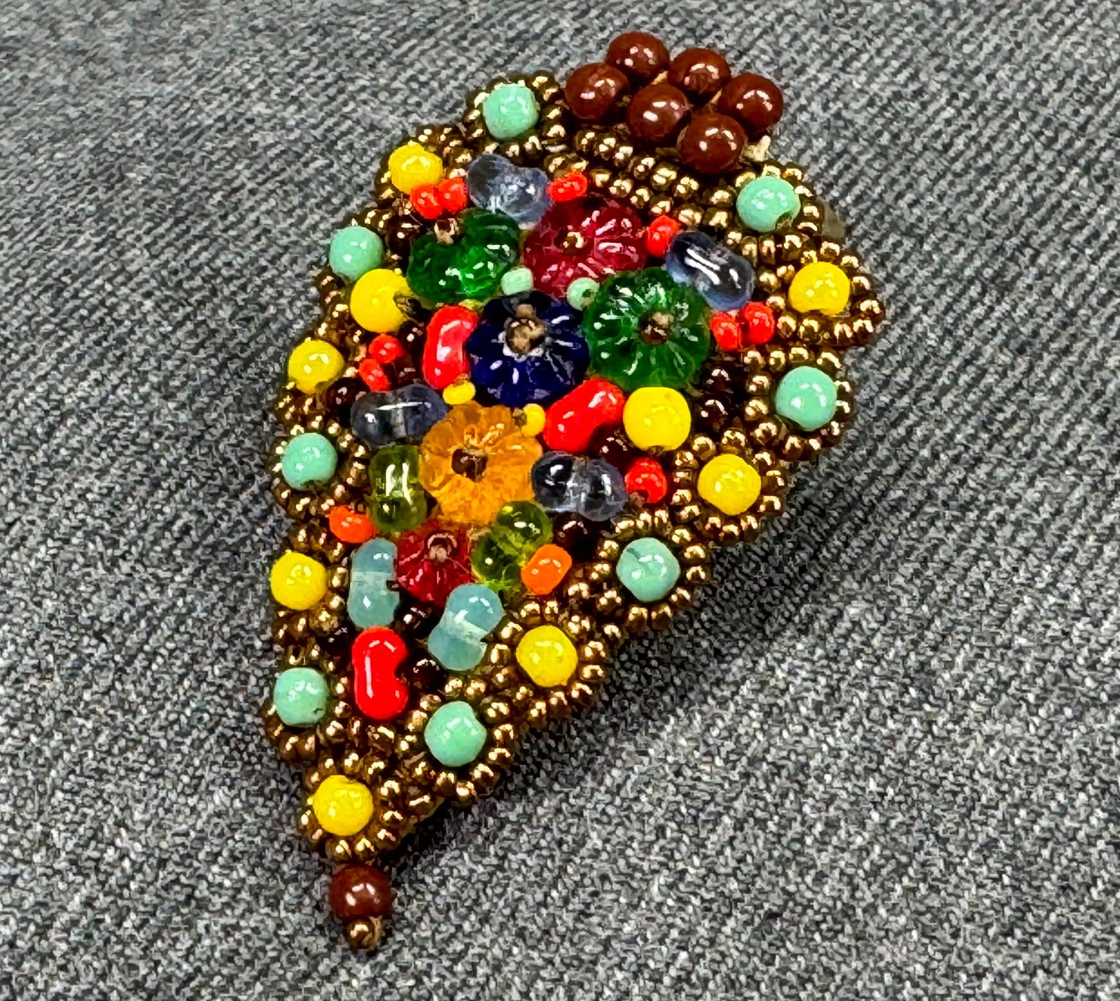 Vintage Haskell style flowers and seed glass beaded brooch clip: Vintage Haskell style flowers and seed glass beaded brooch clip. Unmarked. For measures please refer to the pictures taken with a measuring tape. Weight: 7 Grams IN HOUSE Estimated* SHIPPING & HANDLIN