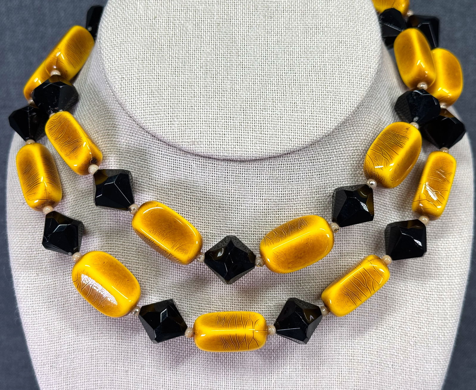 Vintage black & butterscotch plastic beaded necklace: Vintage black & butterscotch plastic beaded necklace. Unmarked. For measures please refer to the pictures taken with a measuring tape. Weight: 62 Grams. IN HOUSE Estimated* shipping and handling cost
