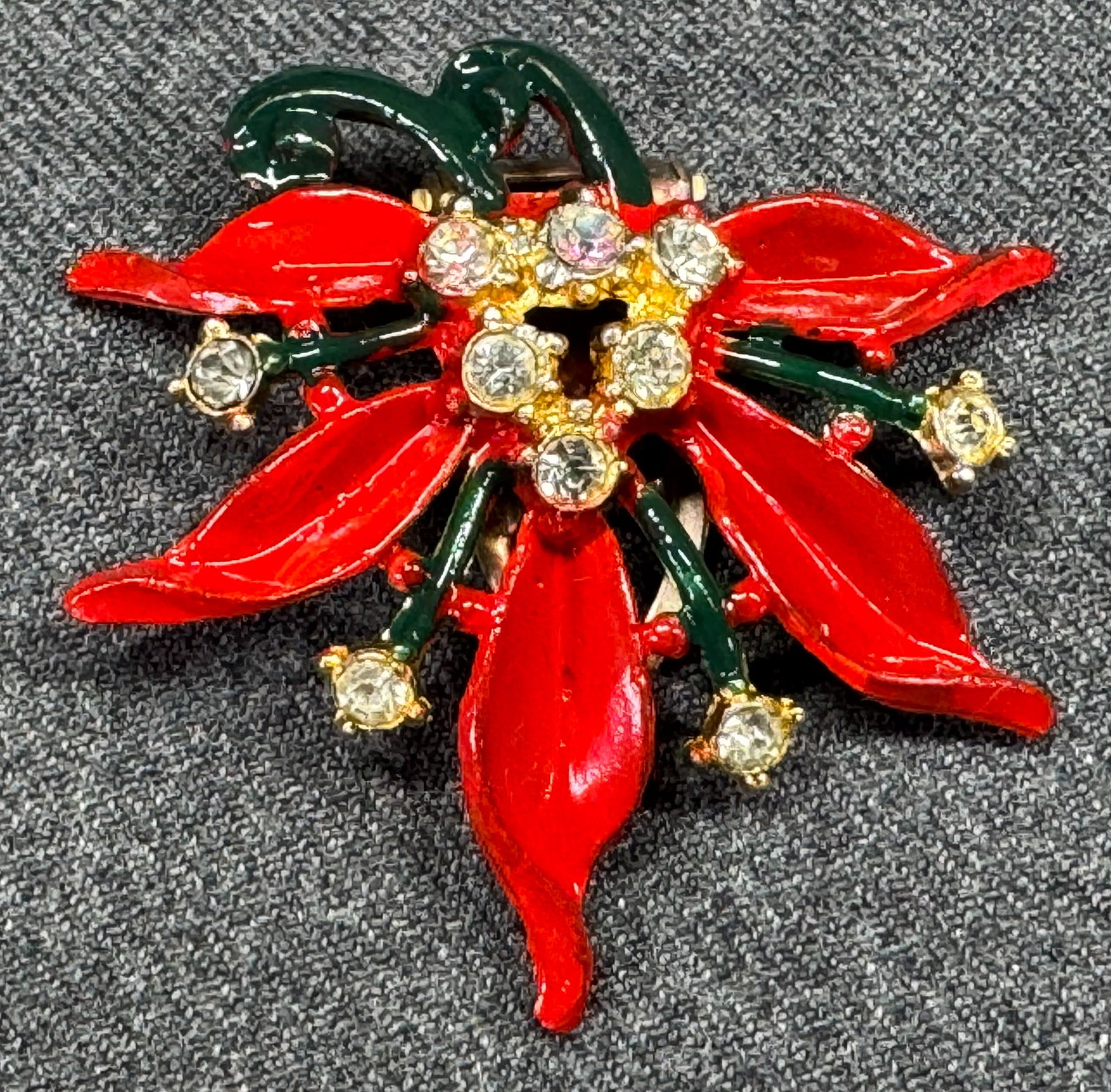 Vintage clear rhinestones enamel pot metal poinsettia flower dress clip brooch: Vintage AB & clear rhinestones enamel pot metal poinsettia flower dress clip brooch. Unmarked. For measures please refer to the pictures taken with a measuring tape. Weight: 15 Grams. IN HOUSE Estimat