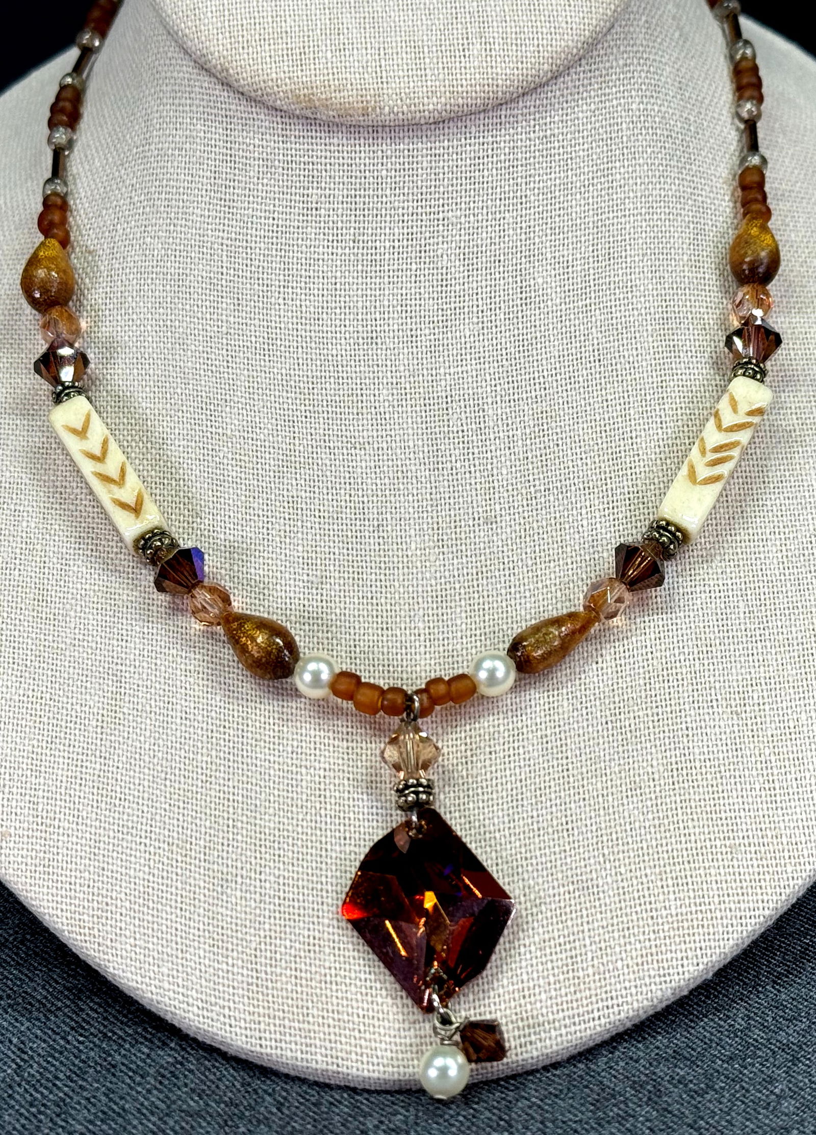 Artsy crystal dangle, bone, glass, metal & pearly beaded necklace.: Artsy crystal dangle, bone, glass, metal & pearly beaded necklace. Unmarked. Silvertone clasp. For measures please refer to the pictures taken with a measuring tape. Weight: 21 Grams. This is a NO RES