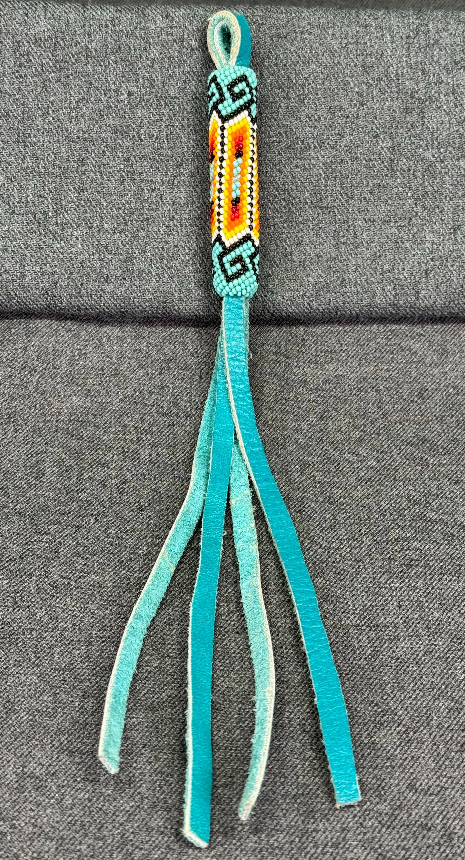 Vintage native American style glass beaded & leather tassel pendant: Vintage native American style glass beaded & leather tassel pendant. Unmarked . For measures please refer to the pictures taken with a measuring tape. Weight: 15 Grams. IN HOUSE Estimated* SHIPPING & 