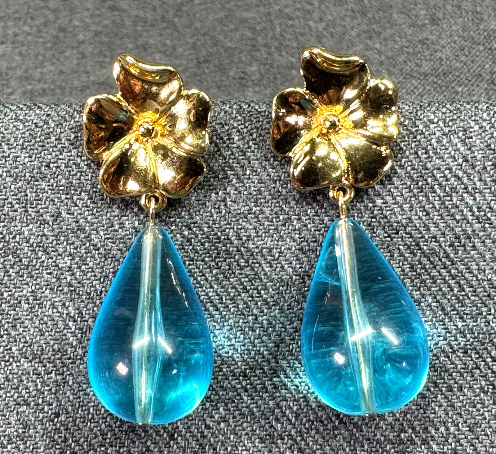 Vintage Trifari TM turquoise lucite drop goldtone metal flower stud earrings: Vintage Trifari TM turquoise lucite drop goldtone metal flower stud earrings. Marked For measures please refer to the pictures taken with a measuring tape. Weight: 12 Grams. IN HOUSE Estimated* SHIPPI
