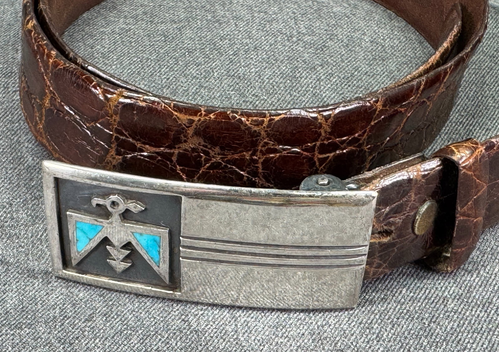 Vintage Navajo turquoise inlay wings thunderbird sterling silver buckle alligator belt: Vintage Navajo turquoise inlay wings thunderbird sterling silver buckle alligator belt. The belt is unmarked. On the back there is an old label that reads the price and Benn. The strap in genuine alli
